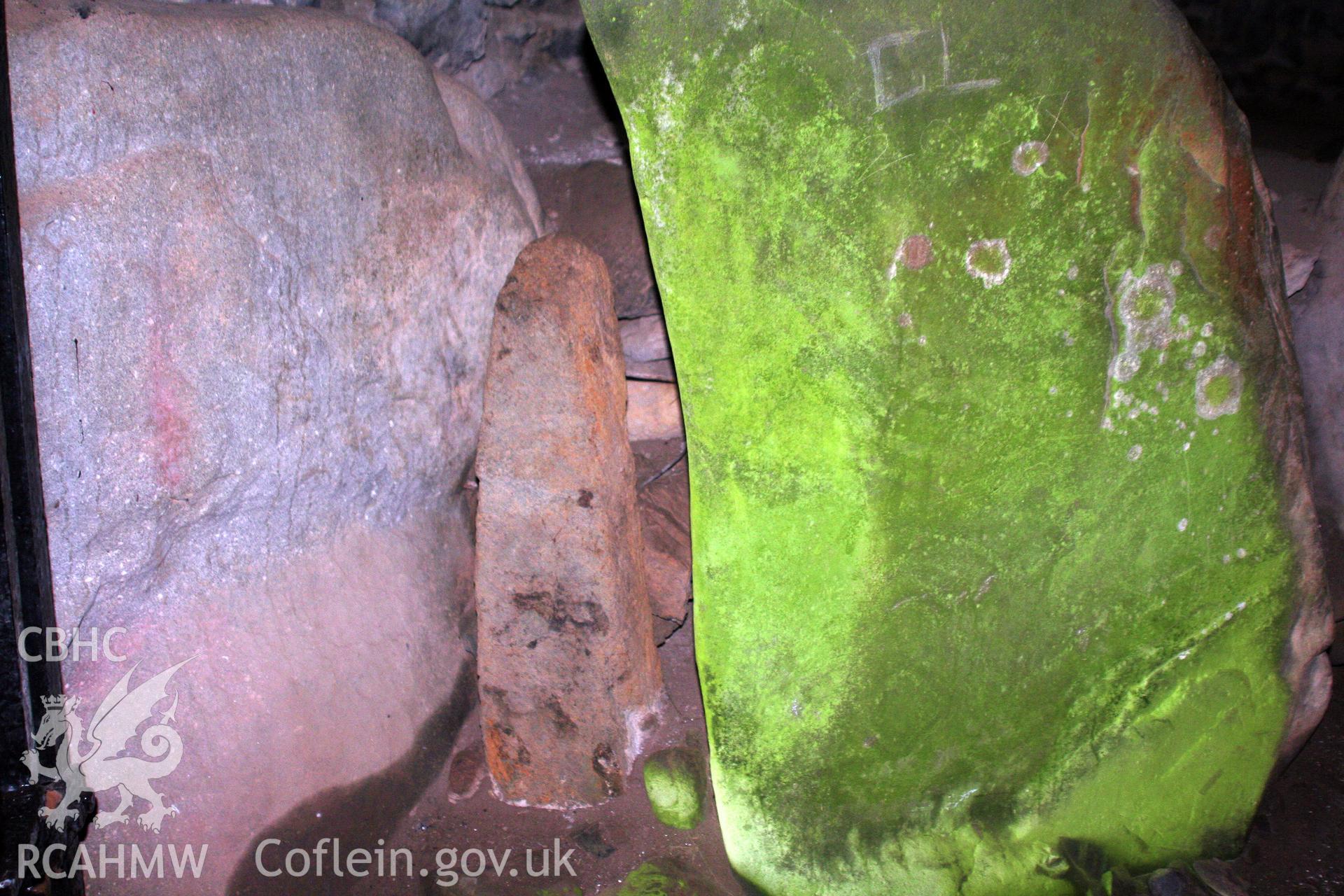 Pillar stone in niche on east side of entrance passage, with carved stone alongside.