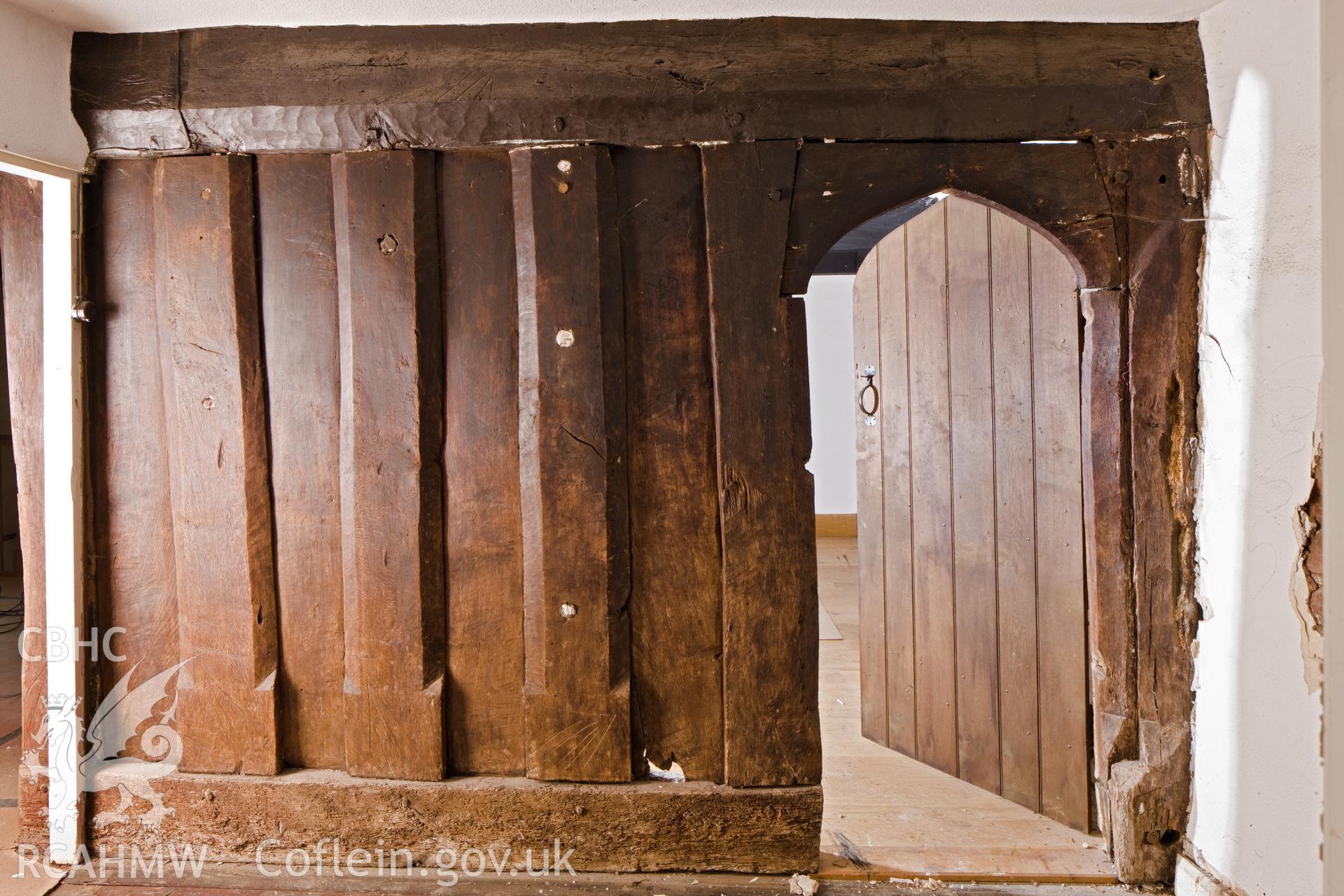 Doorway and post and panel partition into chamber above hall.