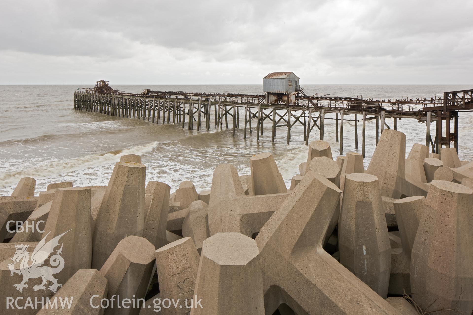 Jetty from the west, coastal erosion protection bollards in foreground.