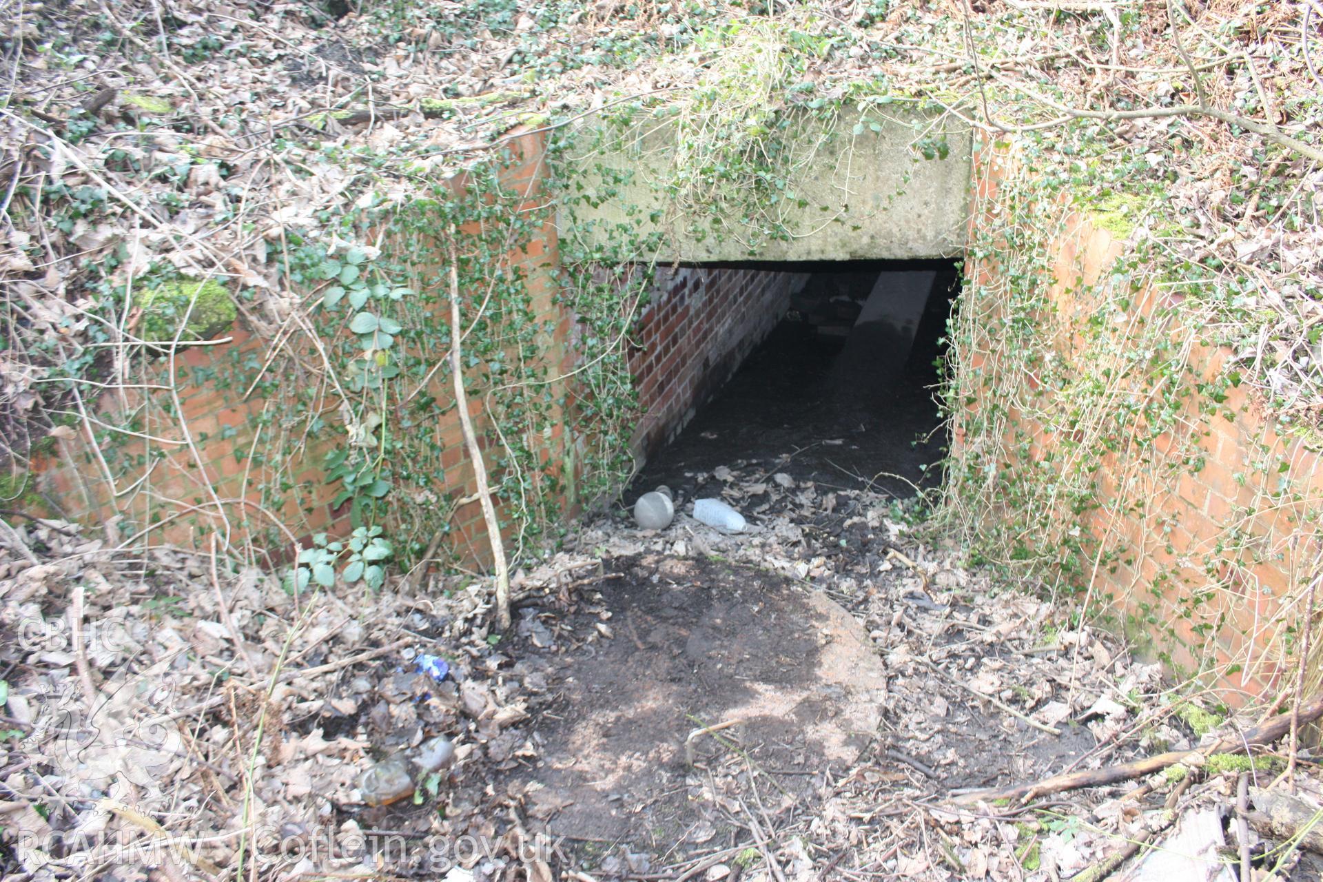 Former coal and clay mining shaft, converted to a storm drain in the 1940s when the modern road was built. The large circular drain covers the former shaft.