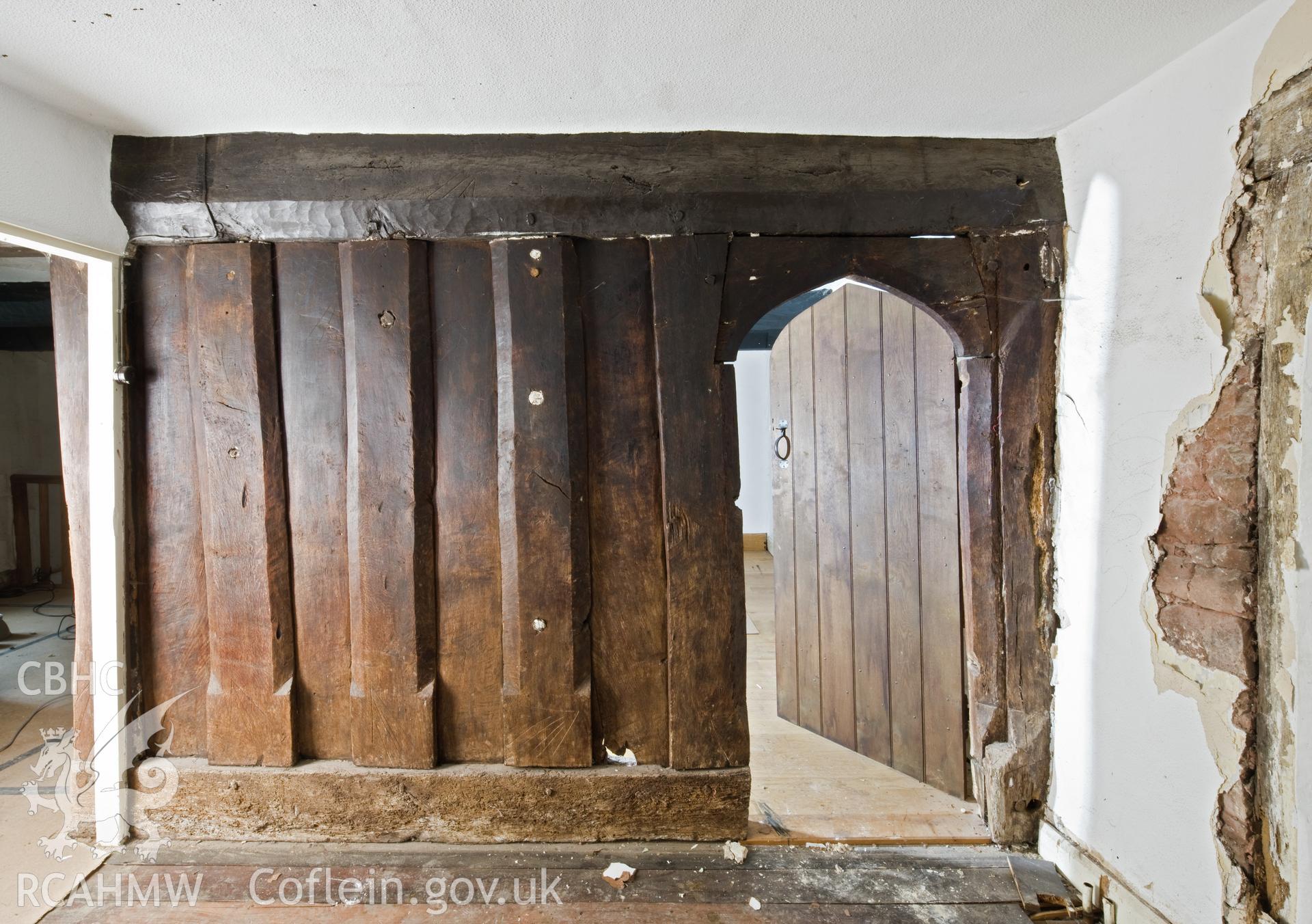 Doorway and post and panel partition into chamber above hall.