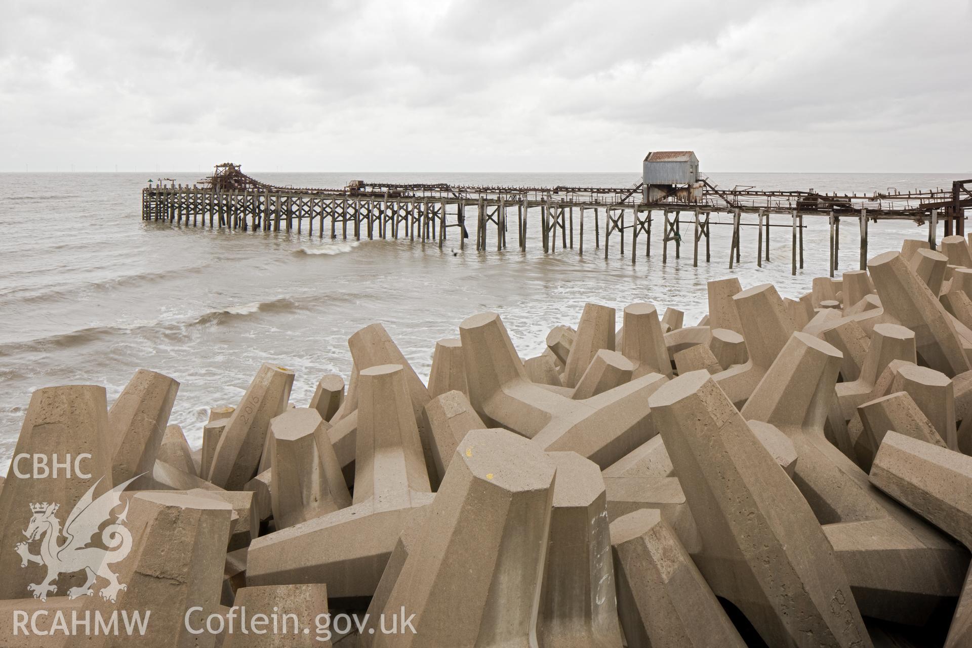 Jetty from the west, coastal erosion protection bollards in foreground.