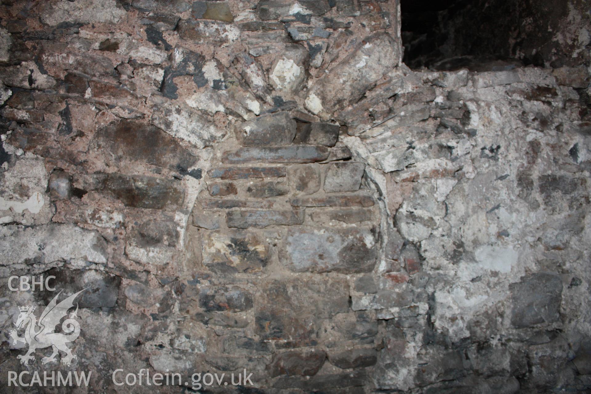 End wall over kitchen fireplace, showing blocked arch opening.