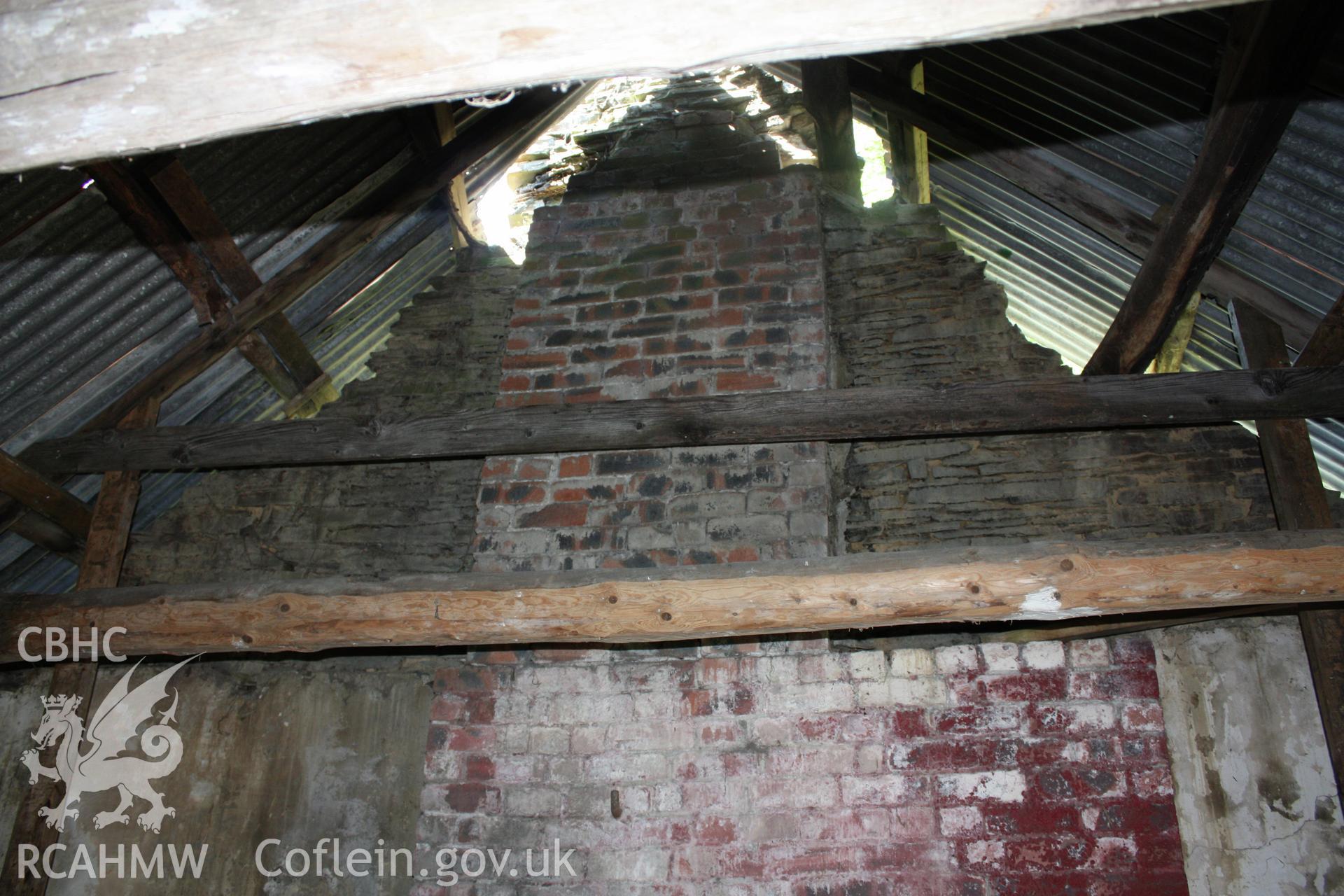 Interior; view towards west gable, showing top of brick chimney breast