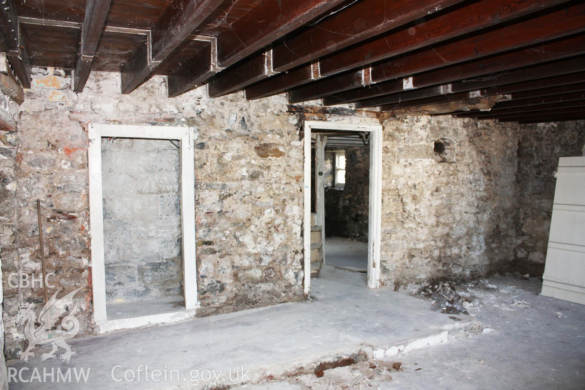 West wall of hall, showing stair projection doorway (blocked) and doorway to kitchen.
