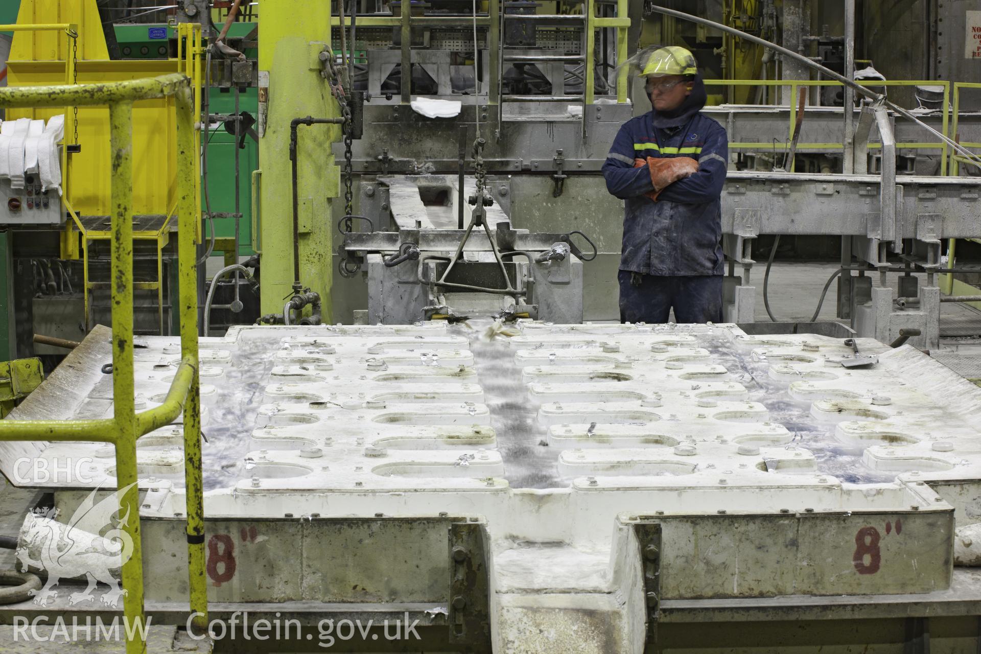 Cast Building and Re-melt, casting pit in operation. Molten aluminium runs from the trough onto the casting table. Anglesey Aluminium, Iain Wright, 5/10/11.