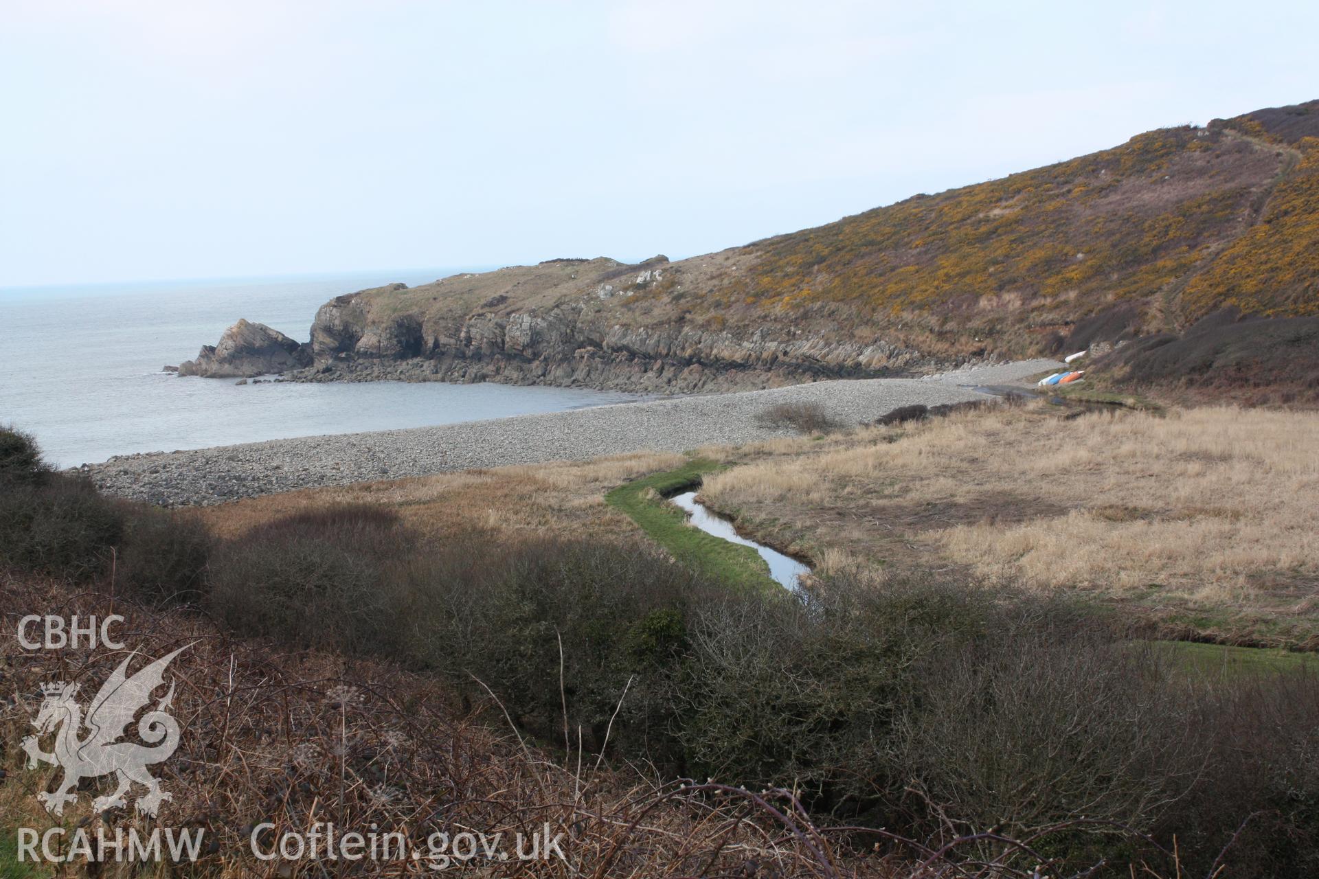 View of the shingle ridge at the head of the bay, with the upstanding roofless remains of the boathouse (NPRN 525072) in close proximity to hauled out canoes