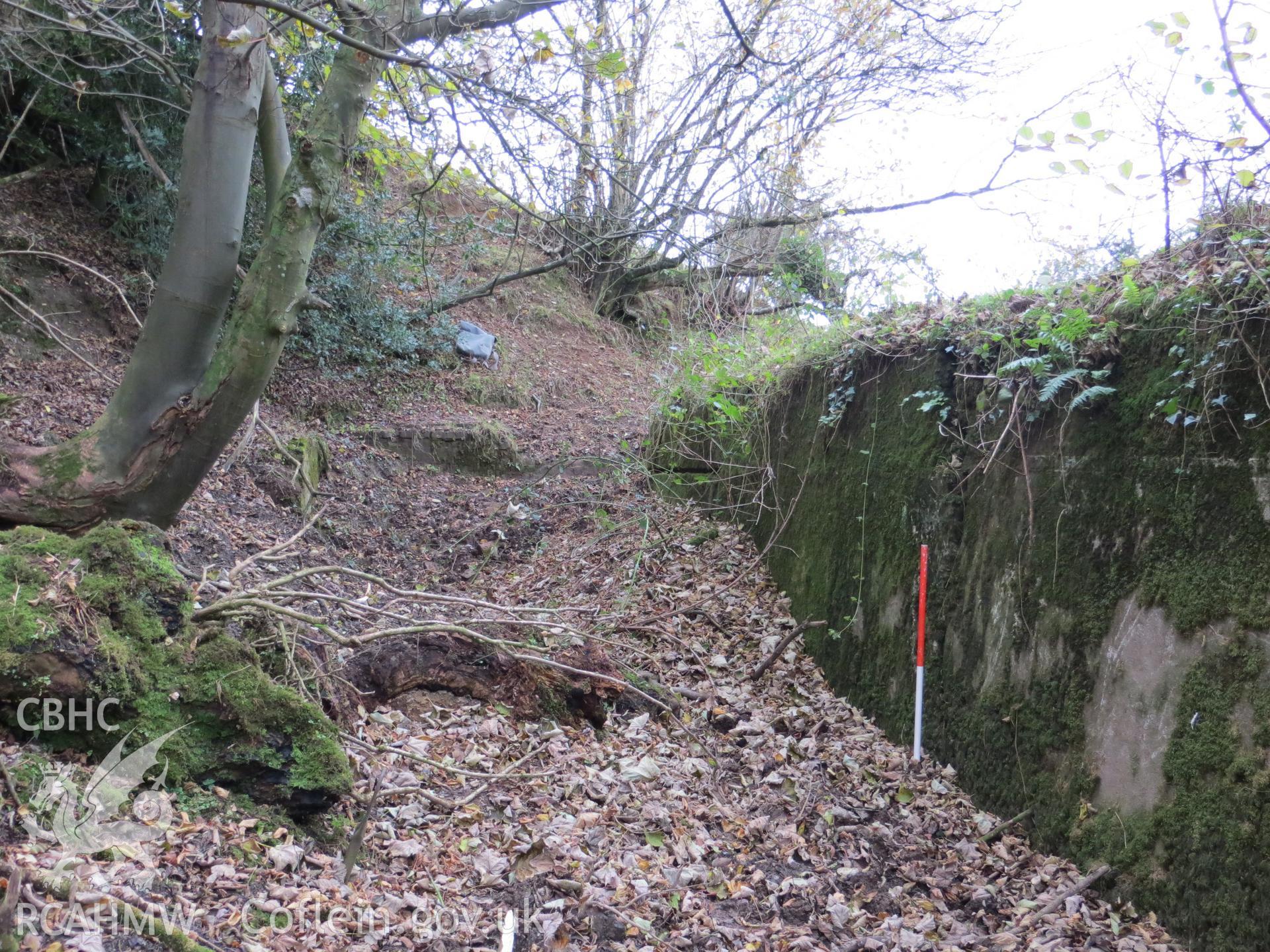Revetment wall and site of control room from the north-east; 1m scale.