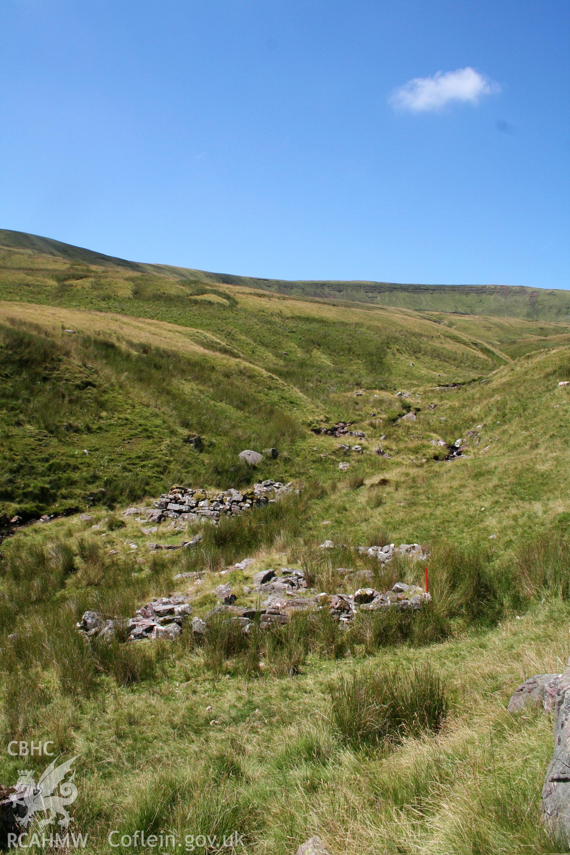 View from the east showing the setting of the houses in the stream cutting; NPRN 408234 in the background.
