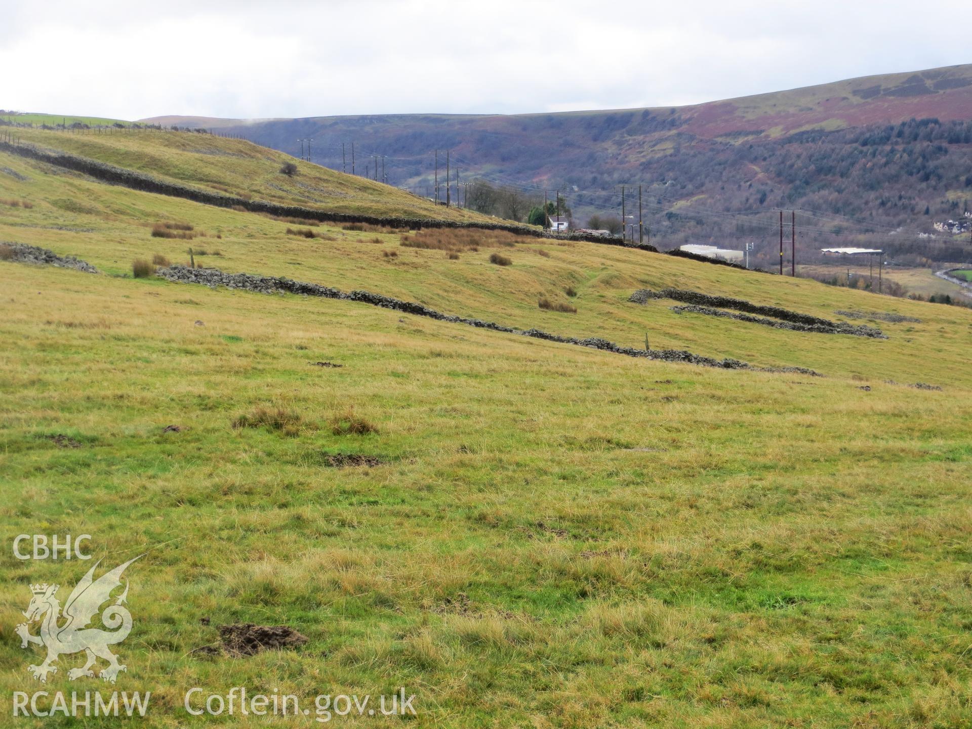 Cultivation ridges outside enclosure with later walled enclosure in background.