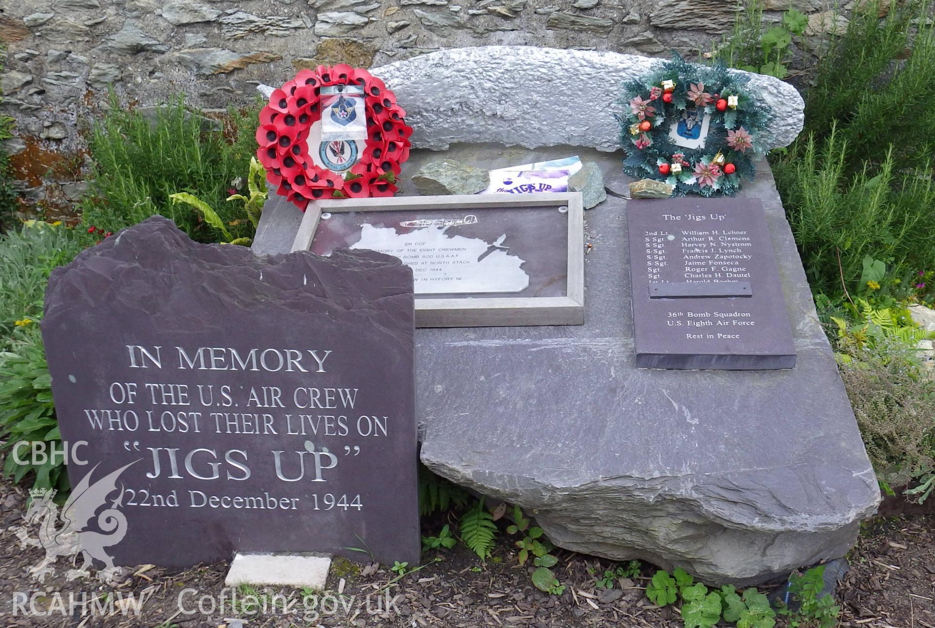 Memorial comprising upright inscribed stone and larger stone with nameboard and part of recovered propellor mounted ontop