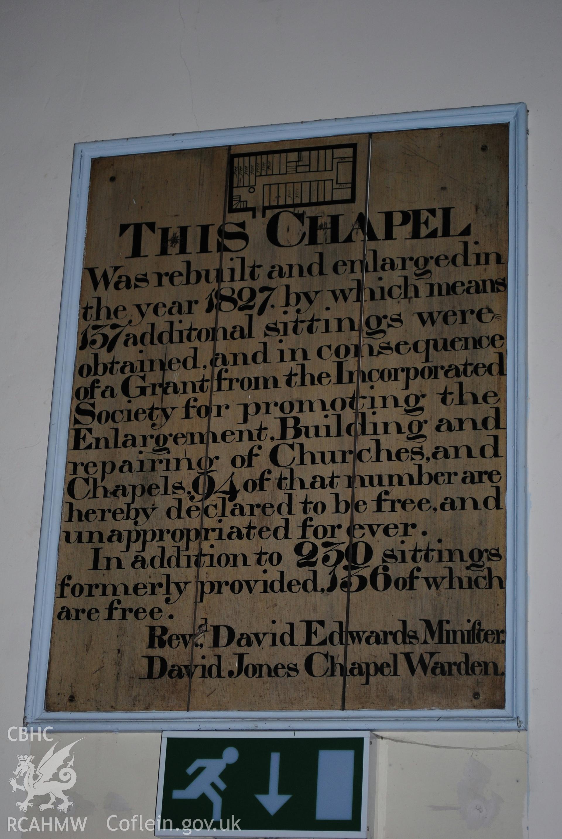 board above door showing original layout and text of renovation works and seating capacity