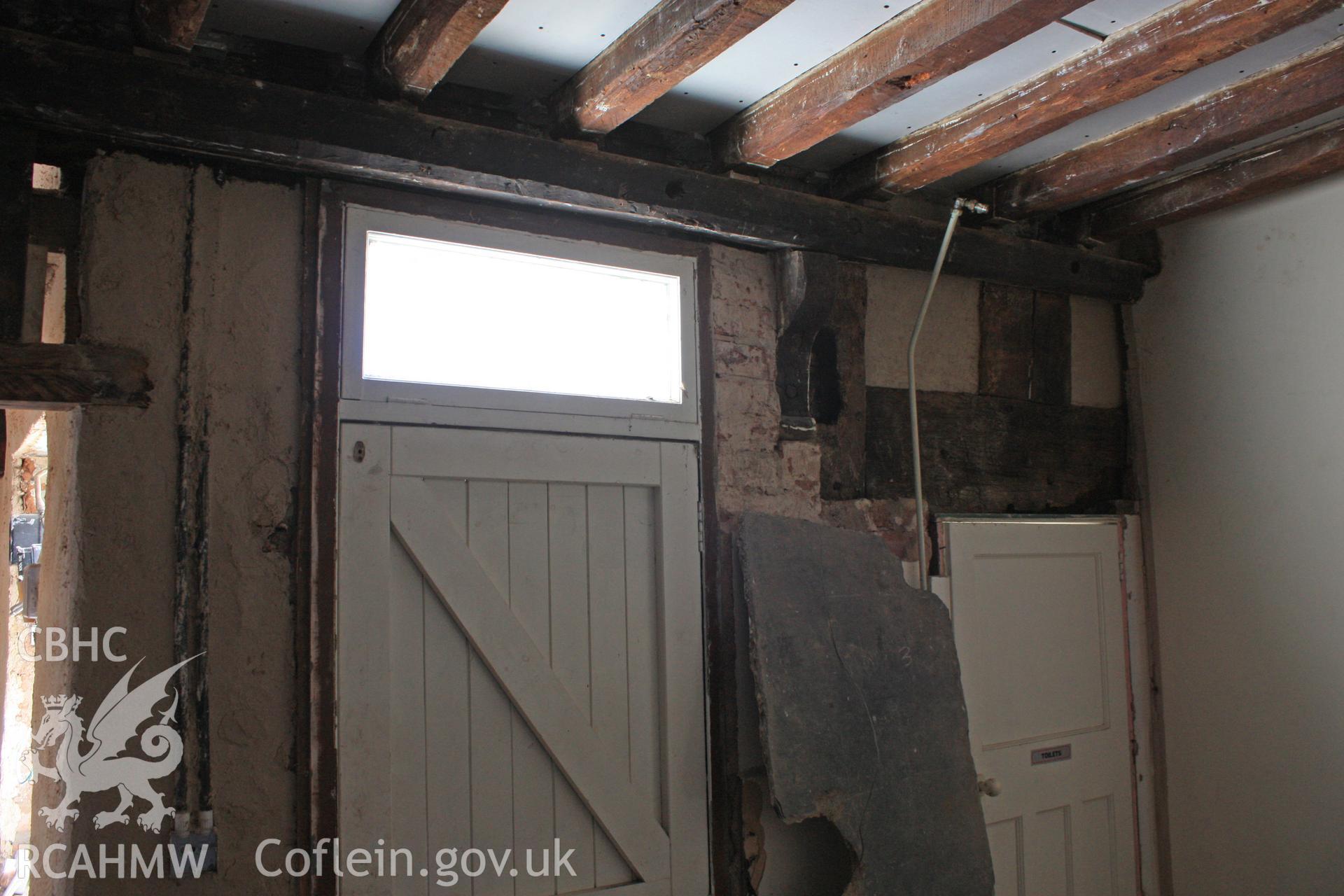 Interior: remains of midrail and studs, with 17th century bracket and beam.