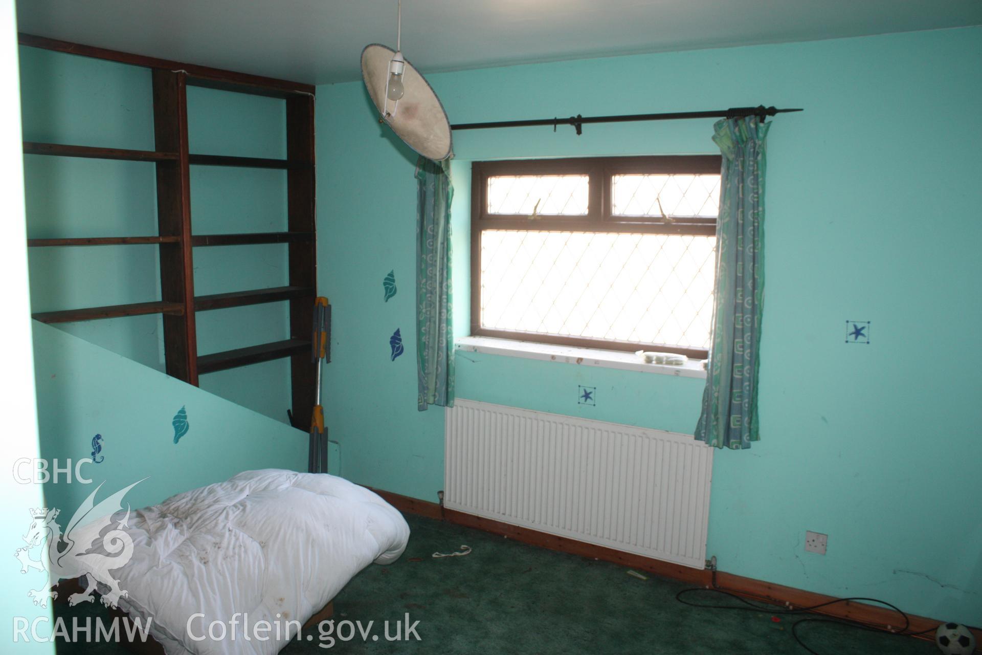 Interior; first floor bedroom above kitchen, showing original line of catslide roof.