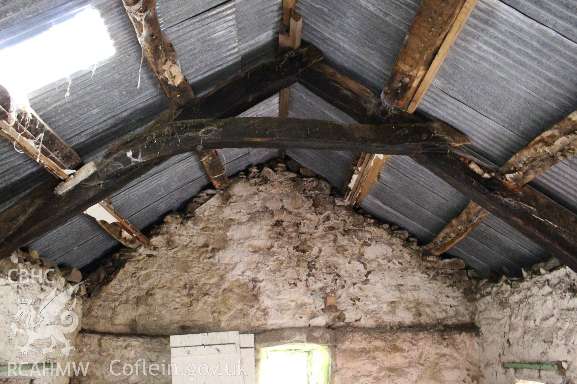 Interior: later truss with collar made from former cruck, ledge to gable wall for supporting joists of a crog-loft.