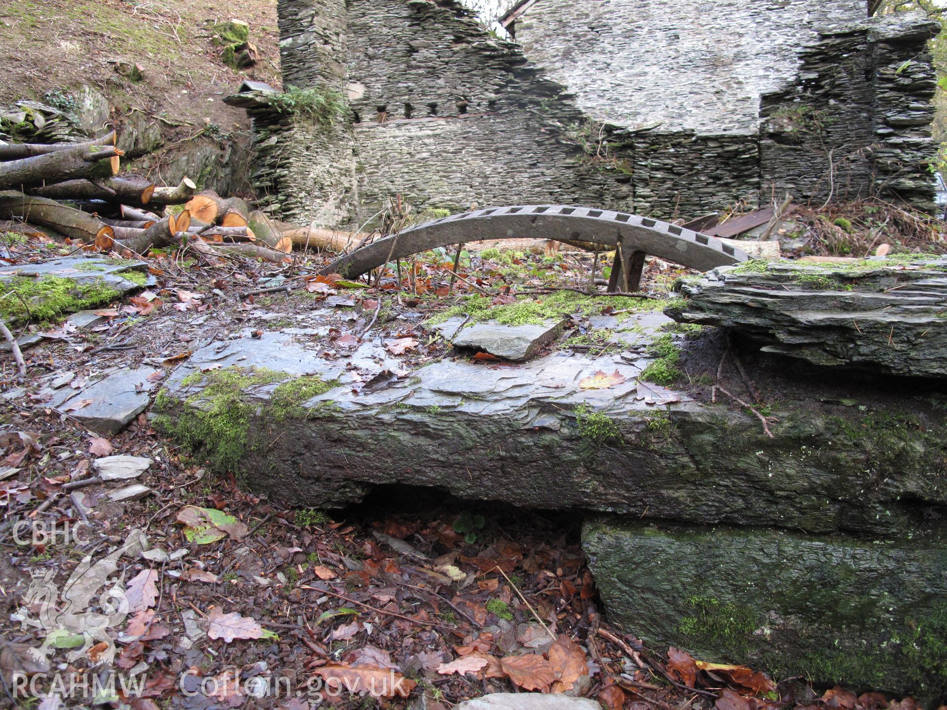Part-buried gear wheel at Fron Factory, Rhayader.