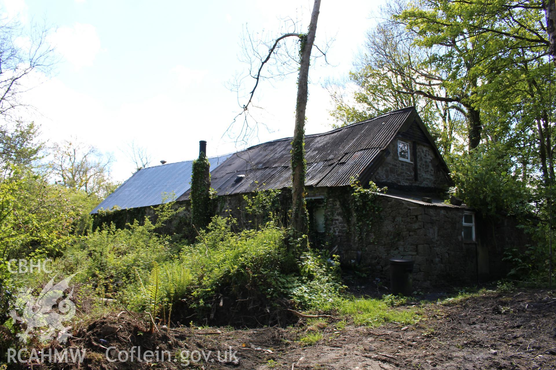 Exterior: 3/4 view of east and north elevation showing position on bank.