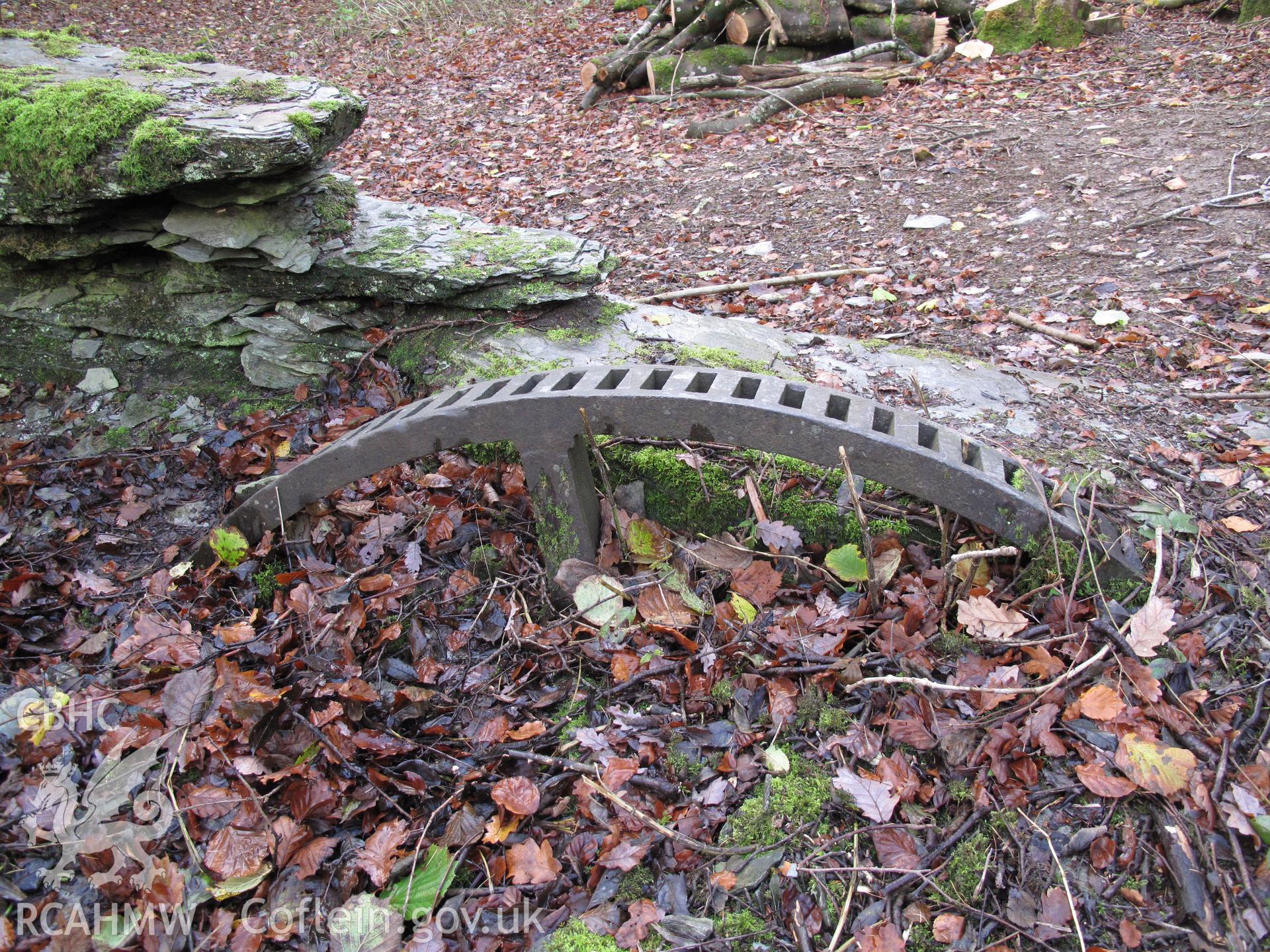 Part-buried gear wheel at Fron Factory, Rhayader.