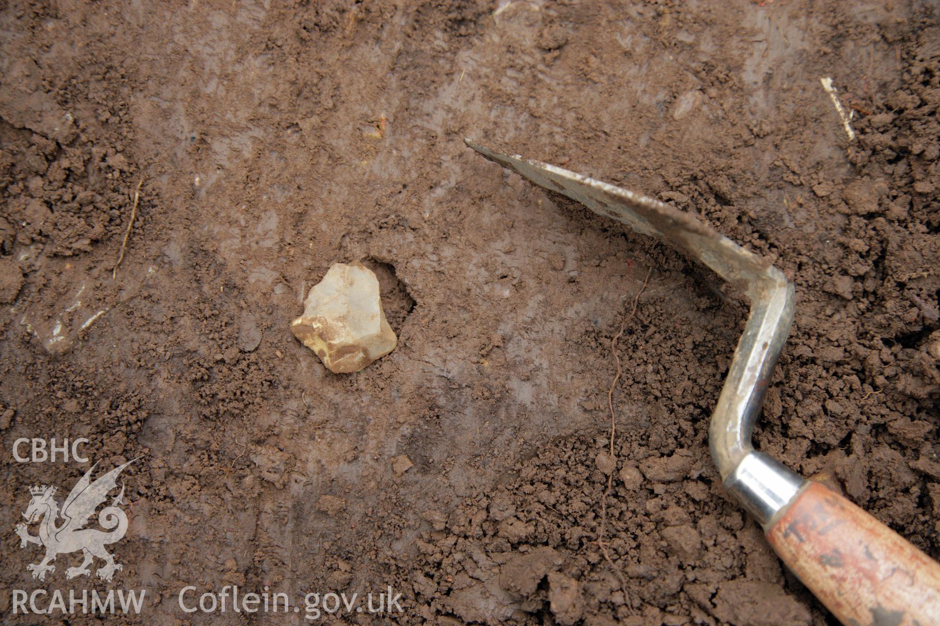 Skomer Island excavation of a burnt stone mound, Hut Group 8. Excavation of Find 18, a flint flake