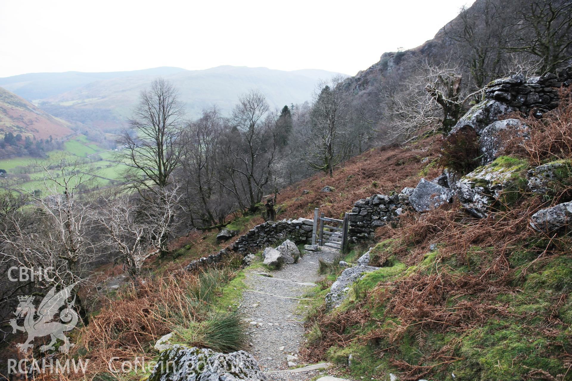 Photo survey of find spot of Tal-y-llyn hoard, beneath naturally-propped boulder alongside path. View from find spot, with spring head below path