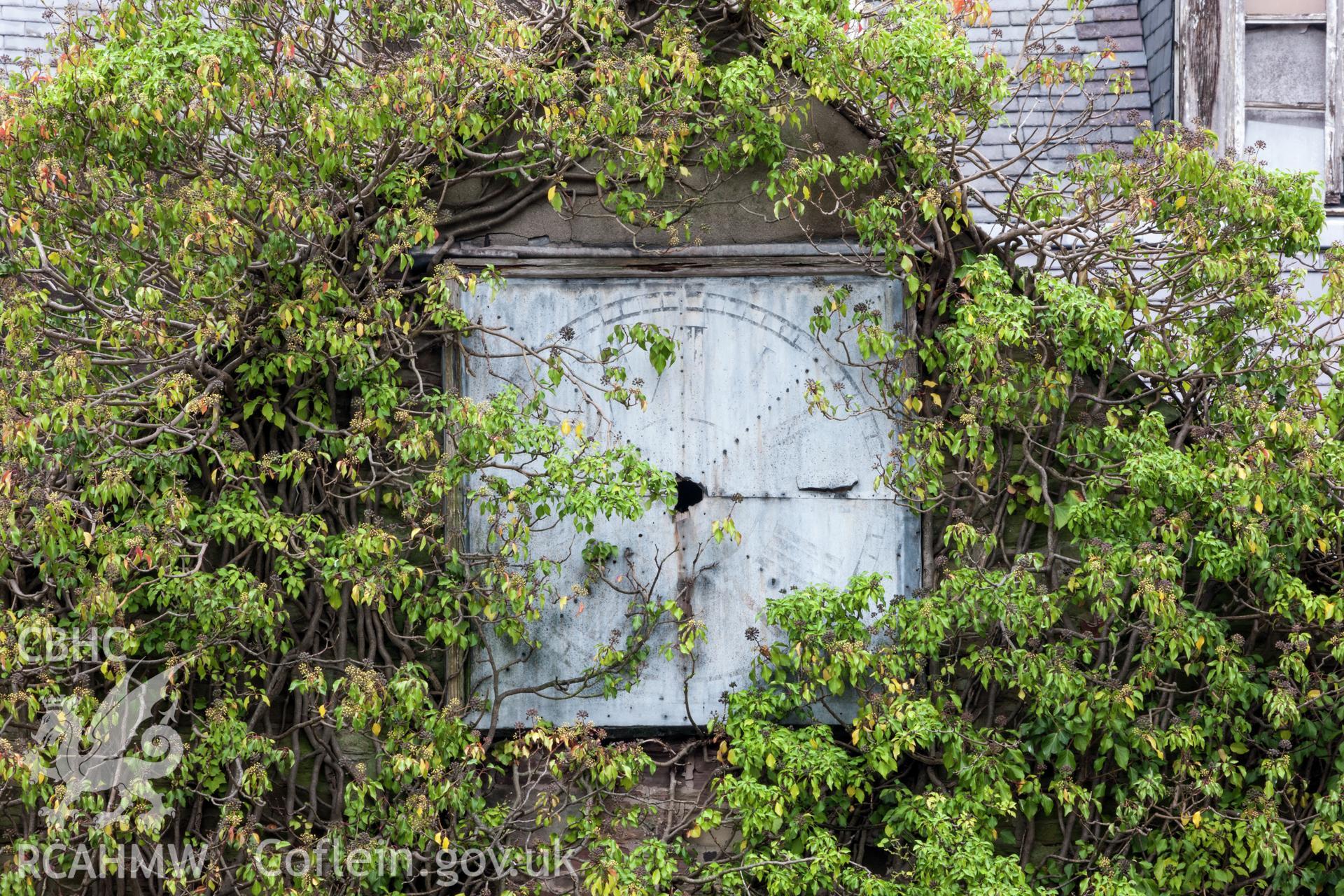 Detail of clock face on building overlooking farmyard