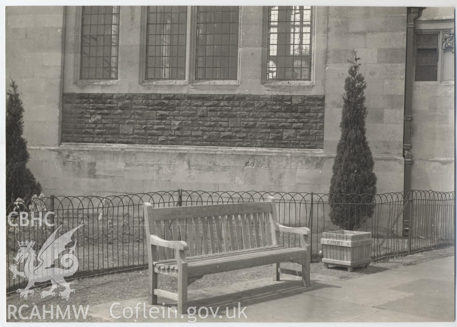 Black and white photograph showing a bench outside Cathays Public Library, Cardiff.