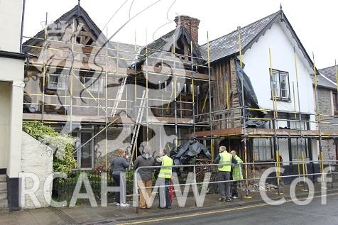 Exterior view showing main elevation following plaster removal, with scaffolding and work personnel.