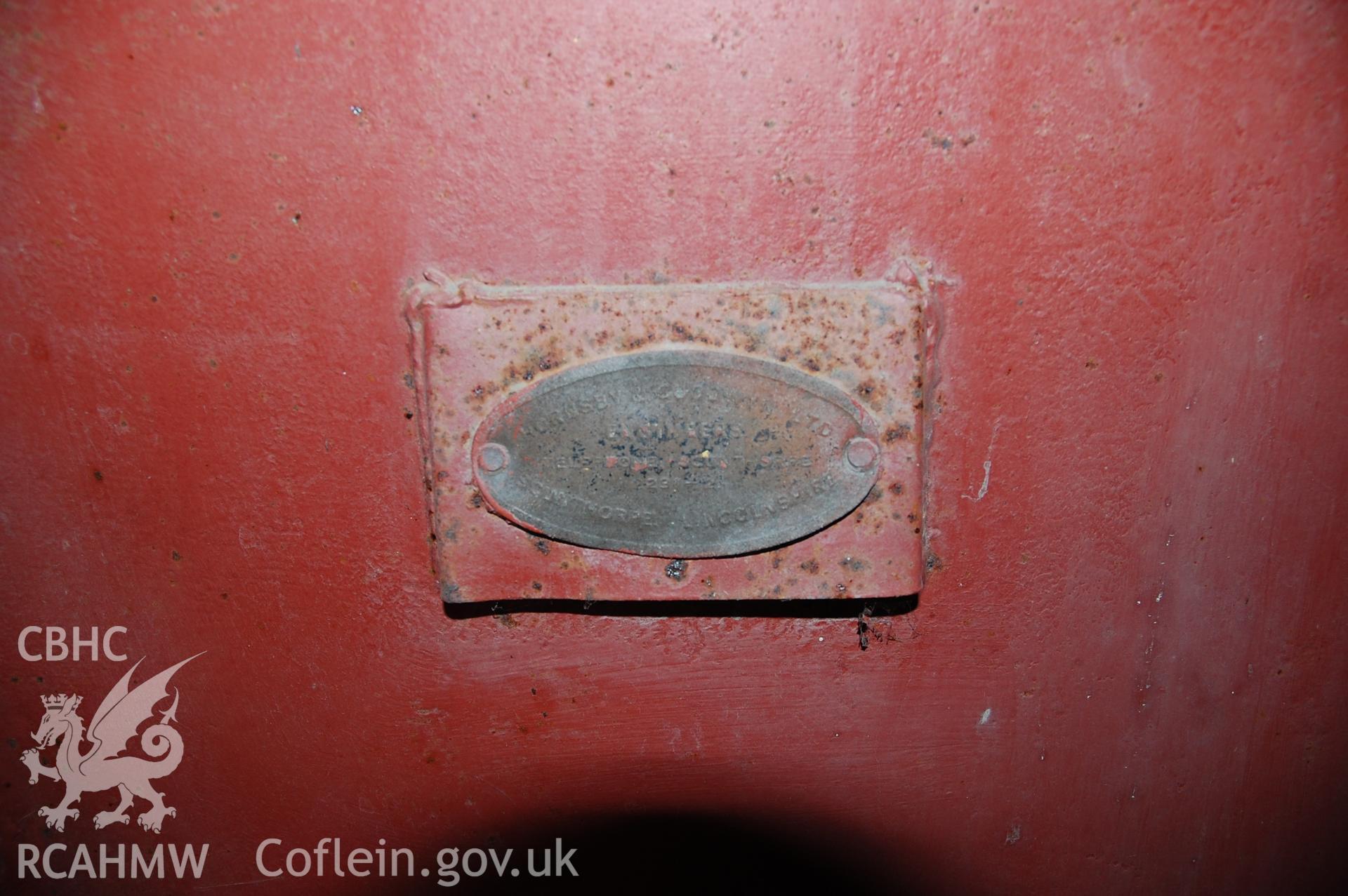 Colour digital photograph showing a North West facing view of a plaque on a metal explosives box in a building at Pen Yr Orsedd Quarry.