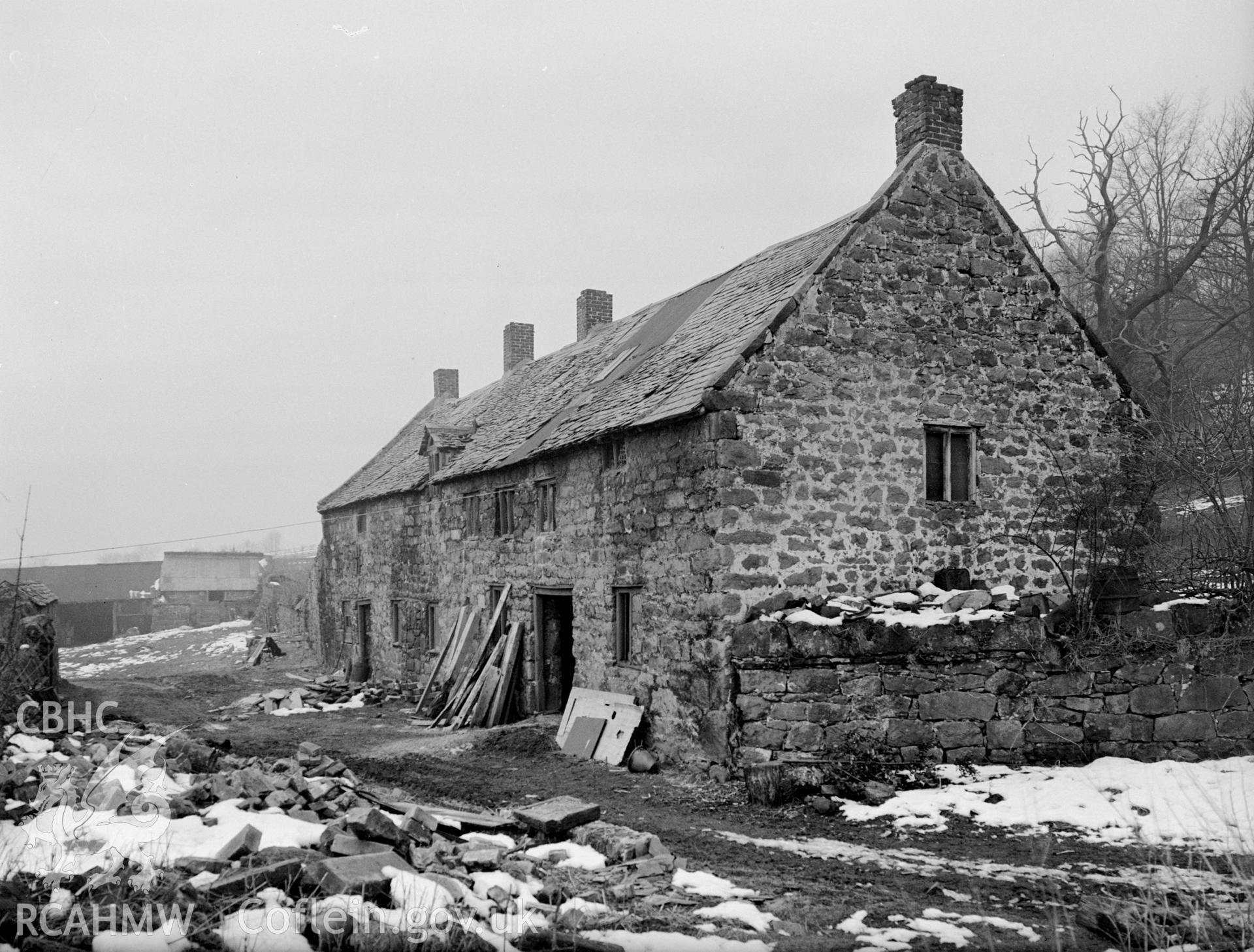 Stone outbuilding with slate pitched roofing and chimneys.