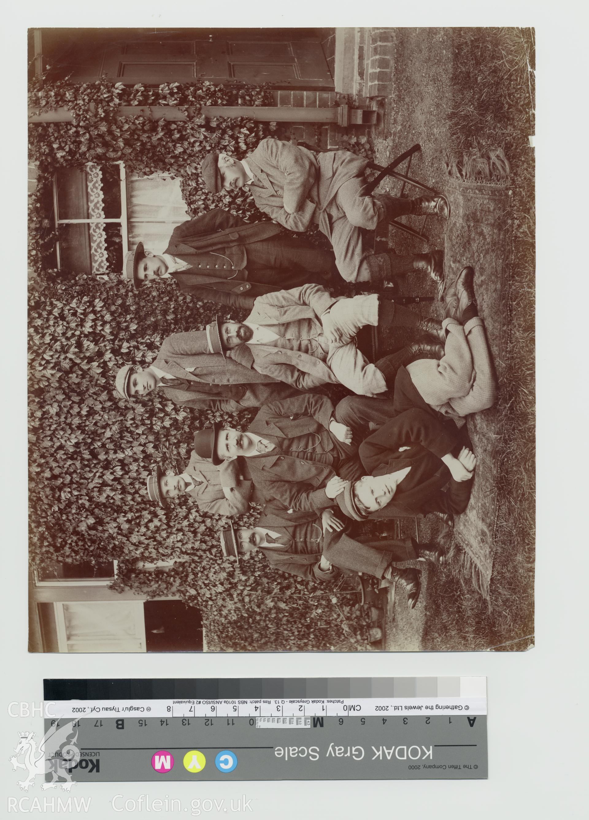 Black and white photograph taken at the time of construction of the Elan Valley Water Scheme, showing a boy with a group of seven gentlemen, presumably engineers, one of whom is thought to be W. A. Legg. Copy negative held.