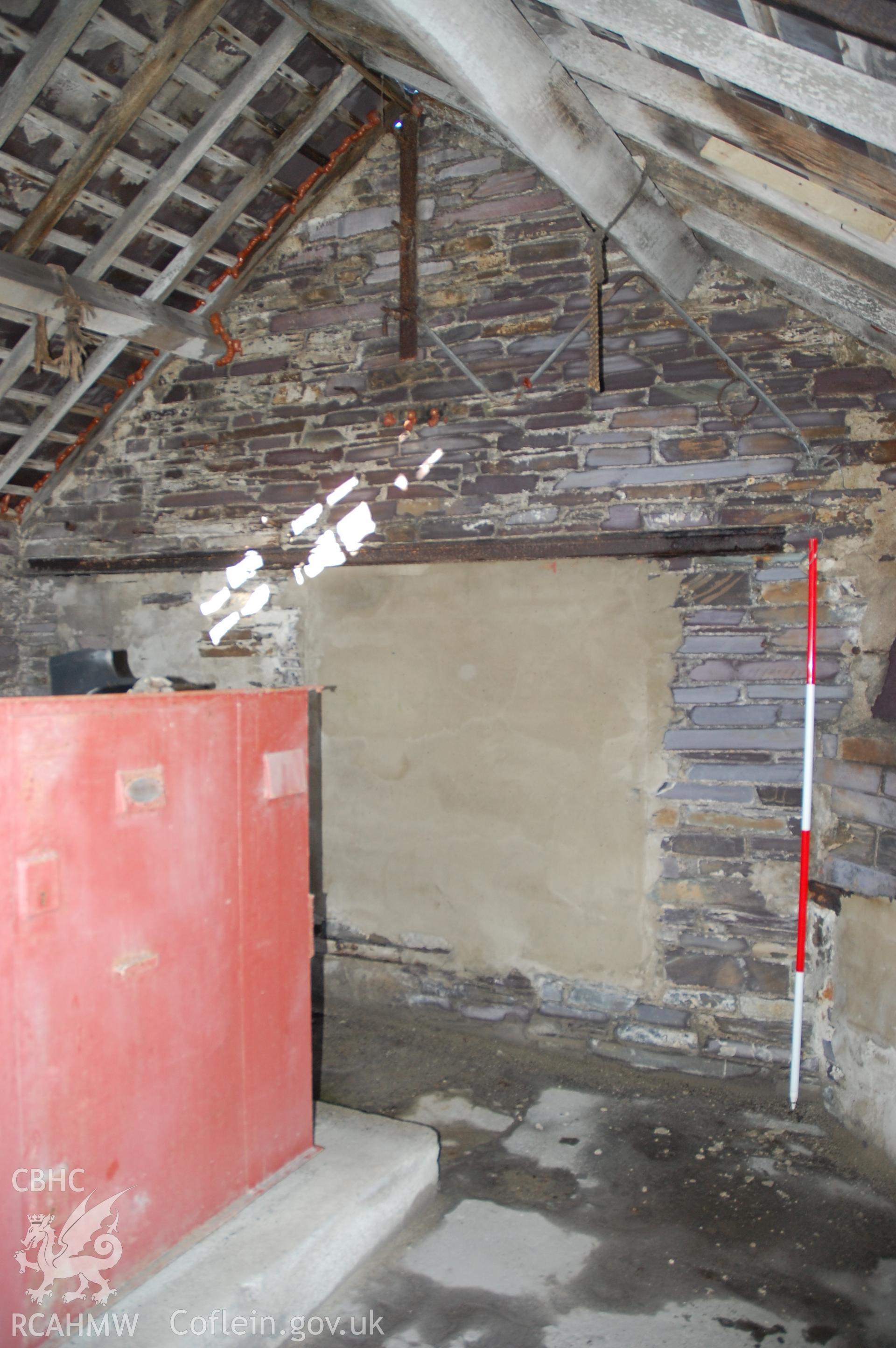 Colour digital photograph showing a North east internal elevation that shows two phases of the blocking of the original winding house opening in a building at Pen Yr Orsedd Quarry.