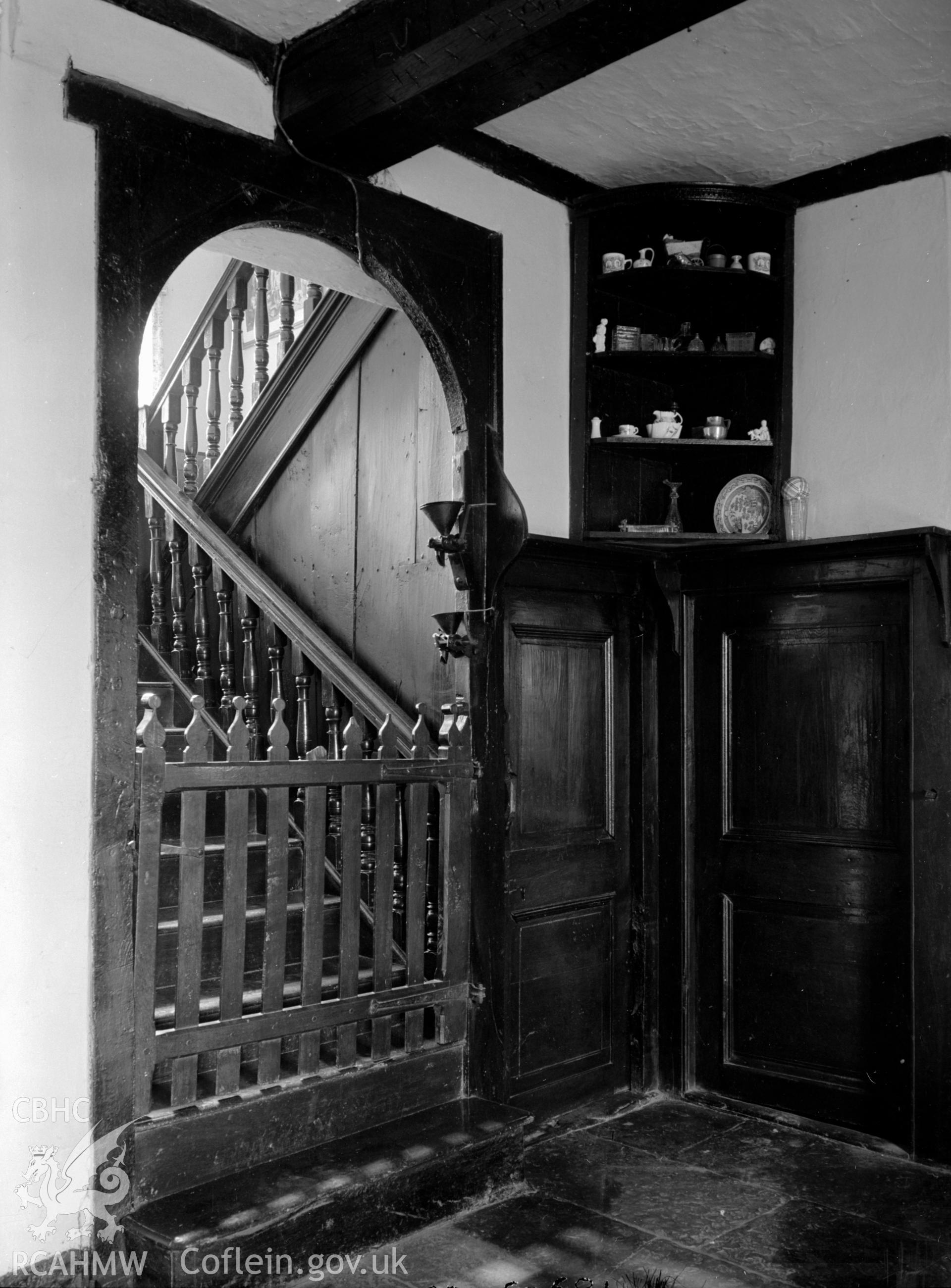 A wooden staircase, with a wooden dog gate at the bottom.