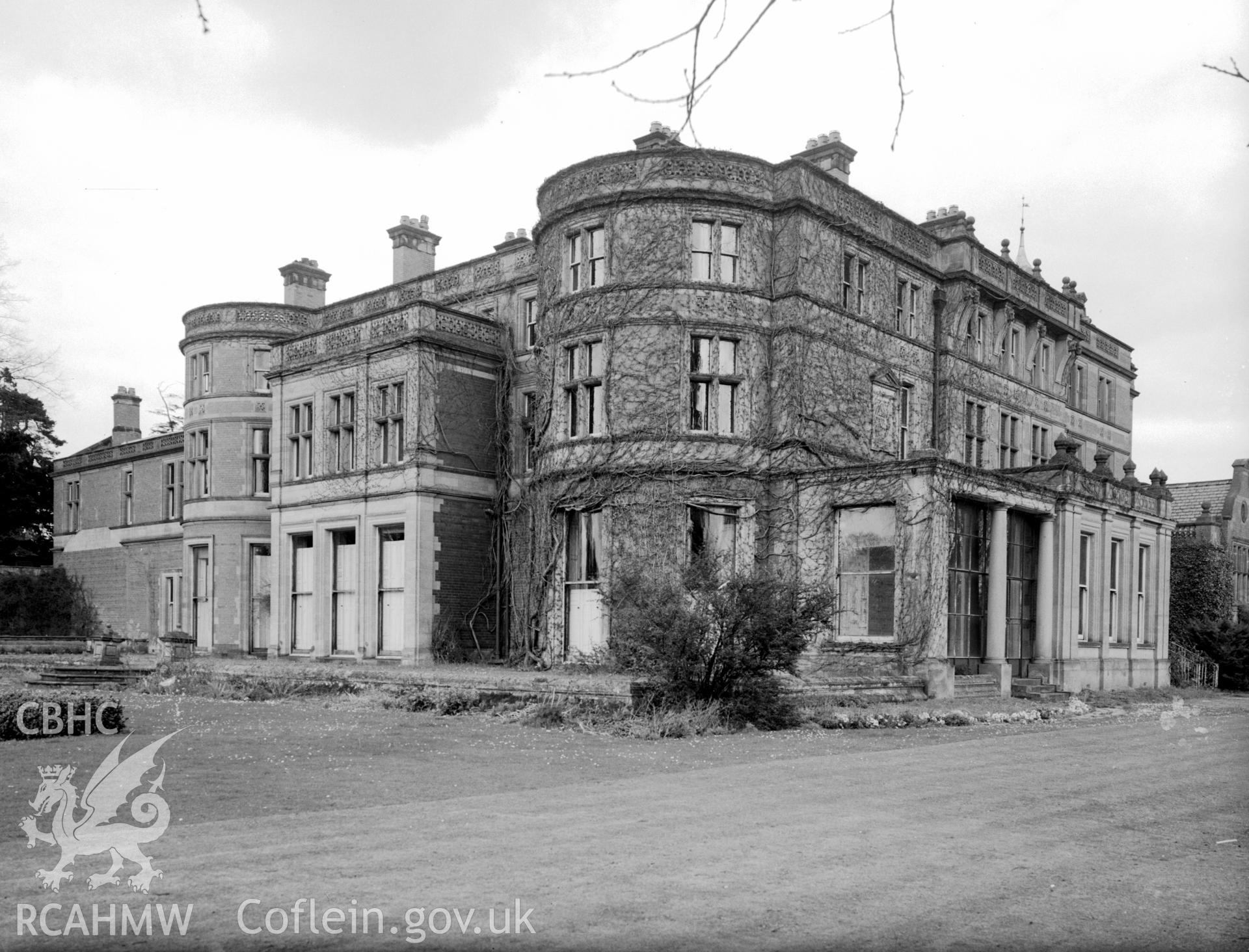 A view of Bryn y Pys Hall from the south west. Showing three storeys, and a porch with Tuscan pillar