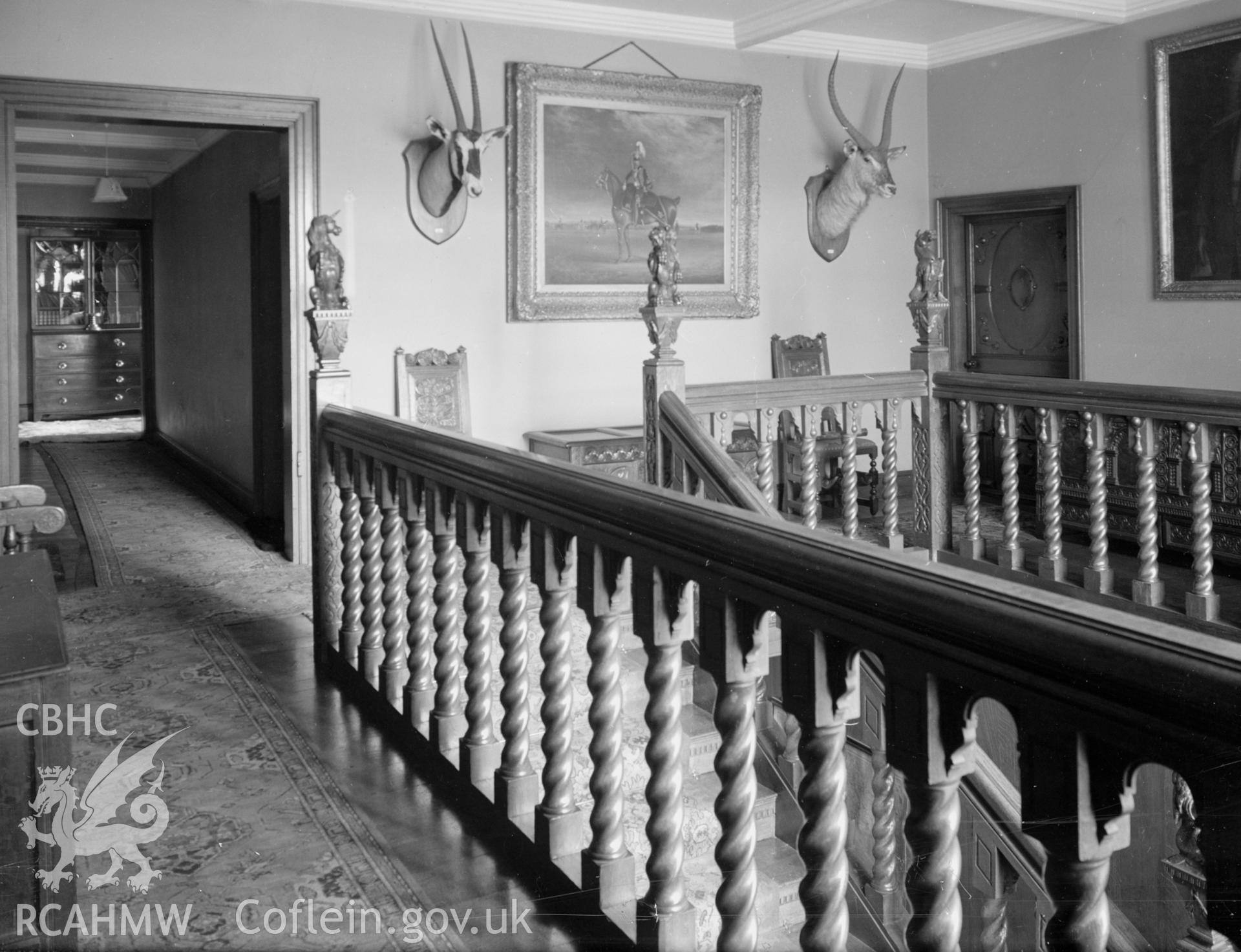 A photograph of the top of the staircase showing the wooden banister and landing.