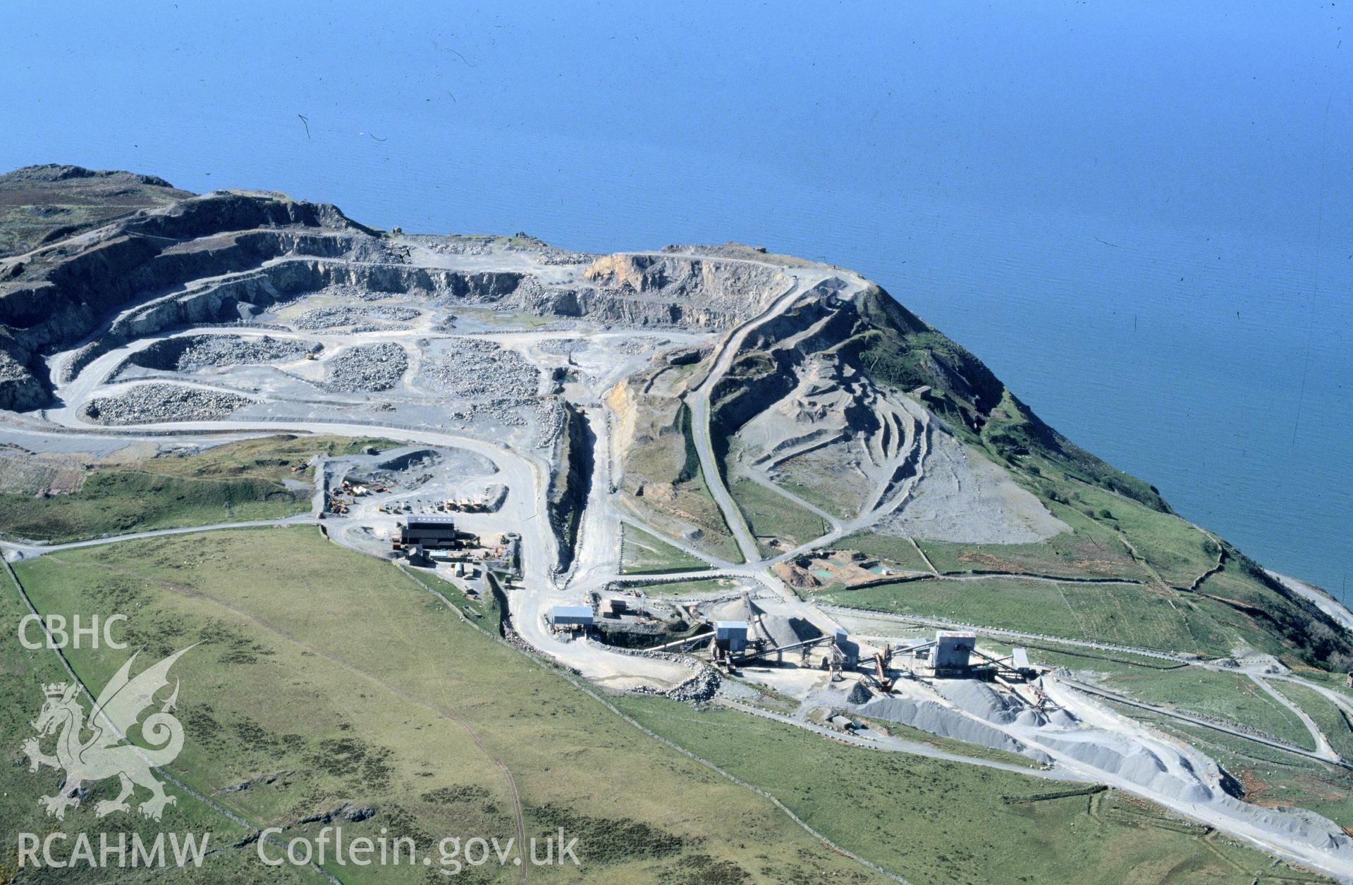 RCAHMW colour slide oblique aerial photograph of Penmaenmawr Stone Quarry, Penmaenmawr, taken by C.R. Musson, 30/04/94