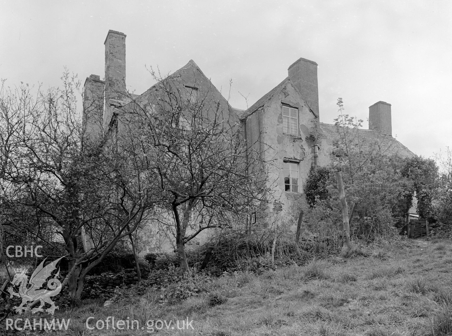 A photograph of the front of the house showing a number of gable fronts and four chimneys.