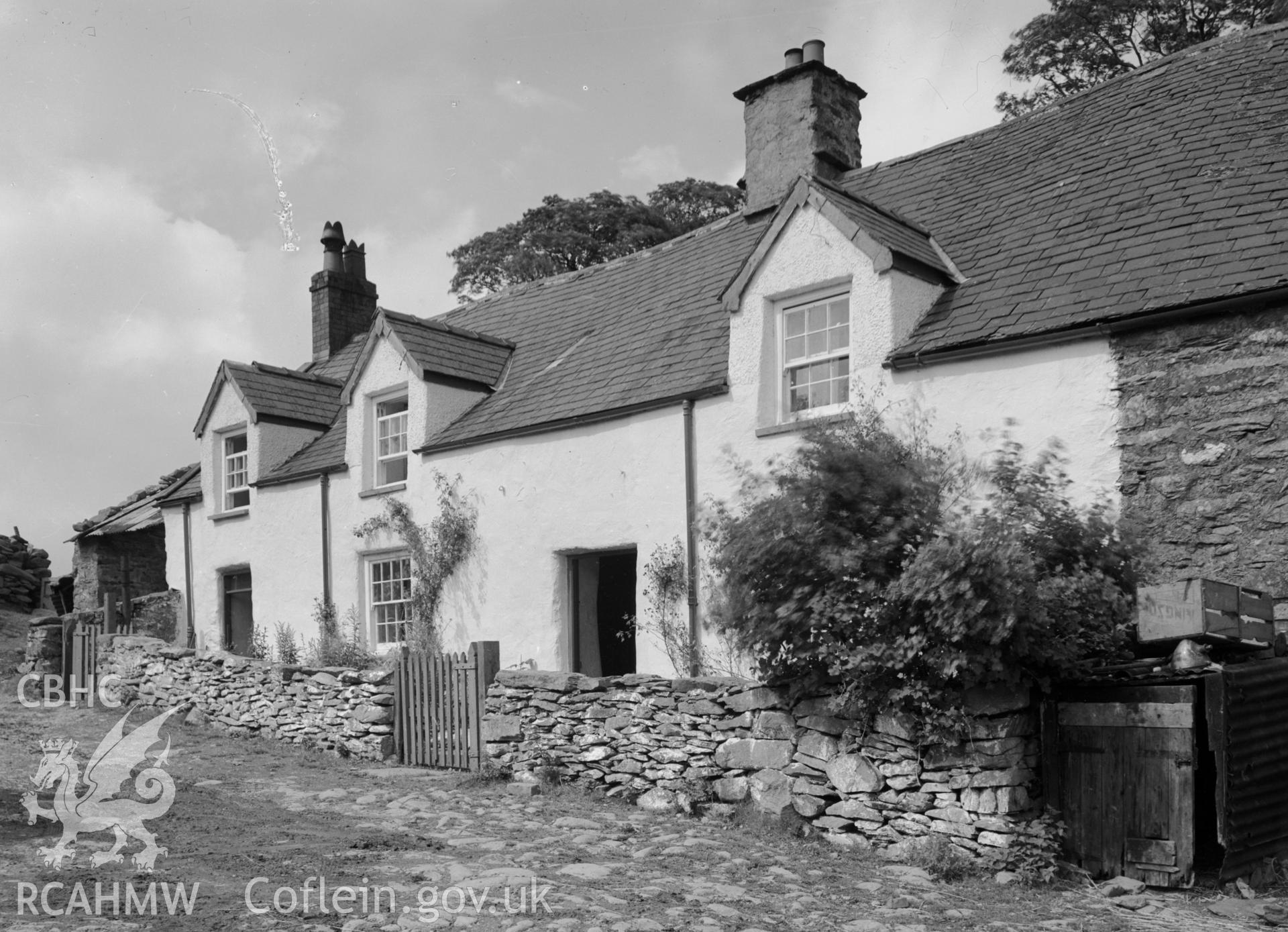 Rectangular stone house possible part of a terrace with a slate pitched roof and two chimneys.