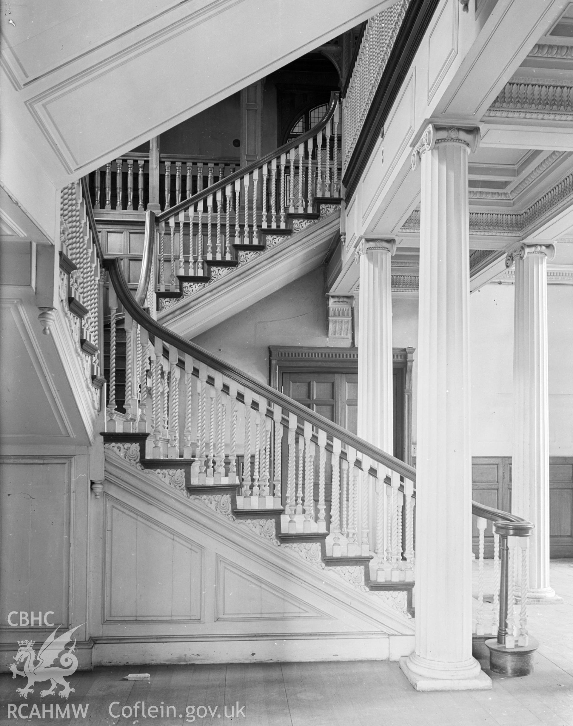A side view of the main staircase, showing the wooden banister and Ionic columns.