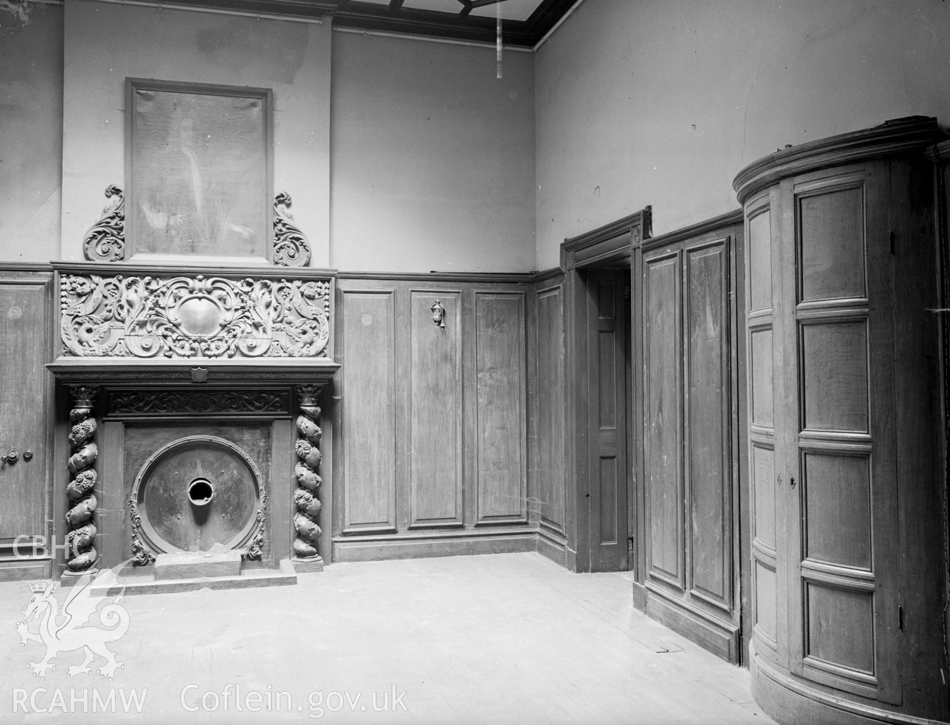 A Small wood panelled room with a carved fireplace, the mantle is supported by spiral columns..