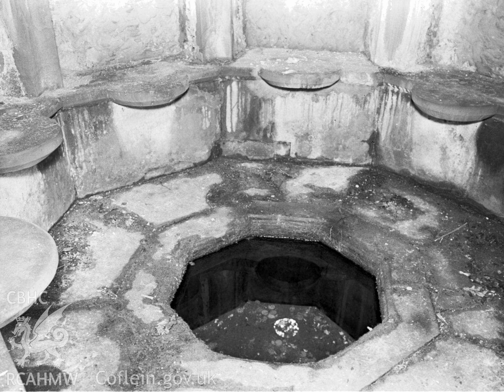 Internal view of St Mary's Well, showing five out of the seven seats circled around the well.