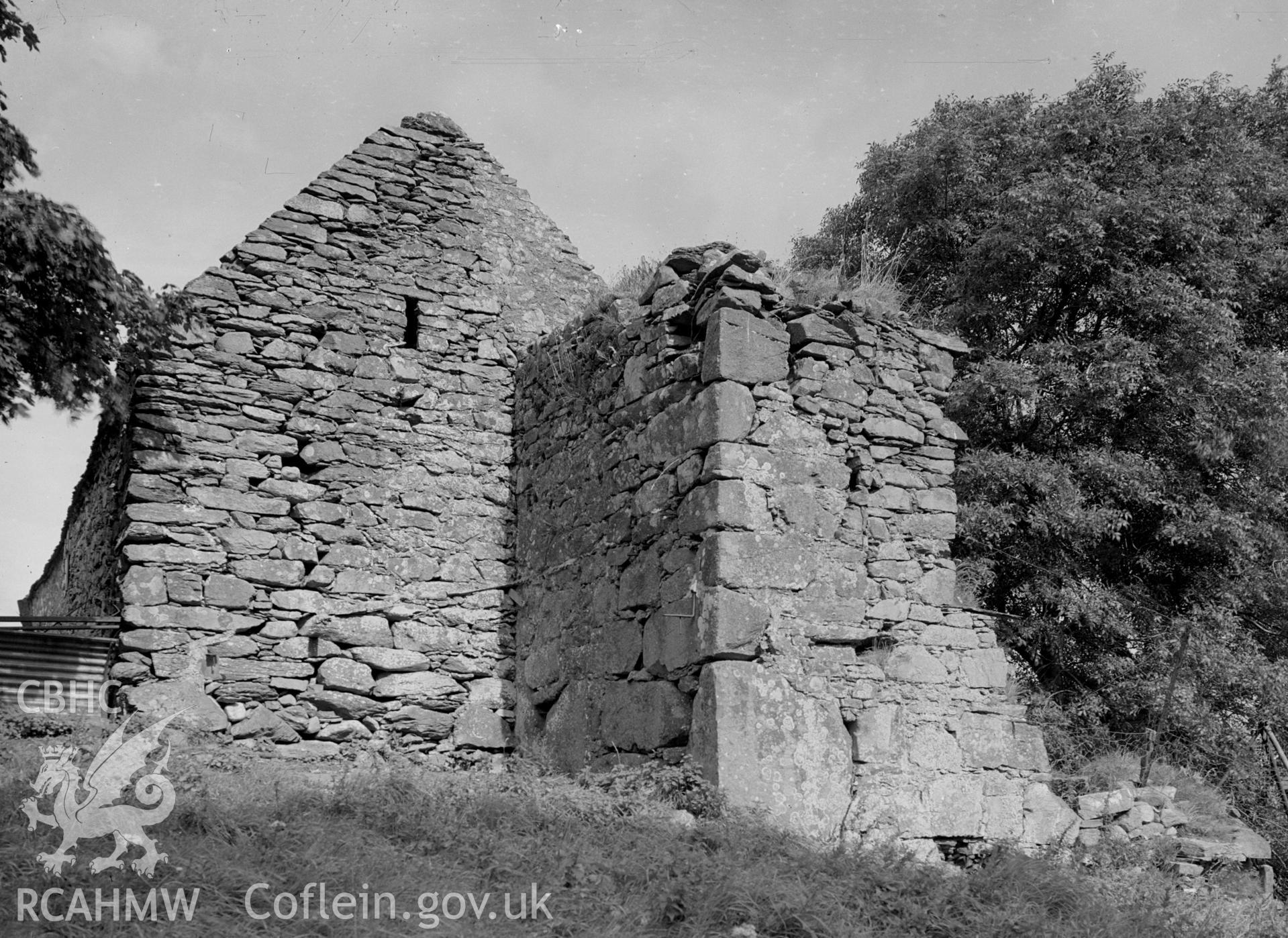 The 16th century gable end of a stone barn with an arrow loop. Remains of a tower are visible.