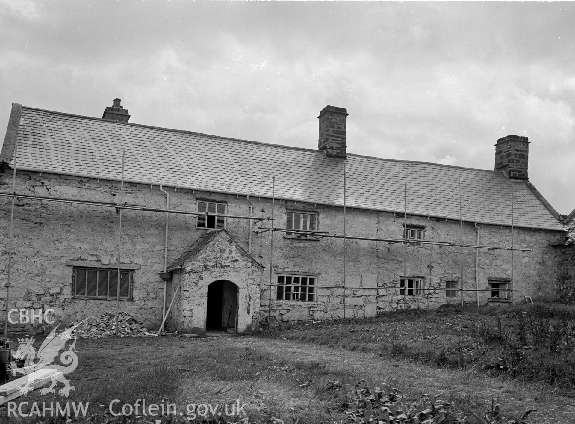 A stone rectangular house with a slate pitched roof and three chimneys.