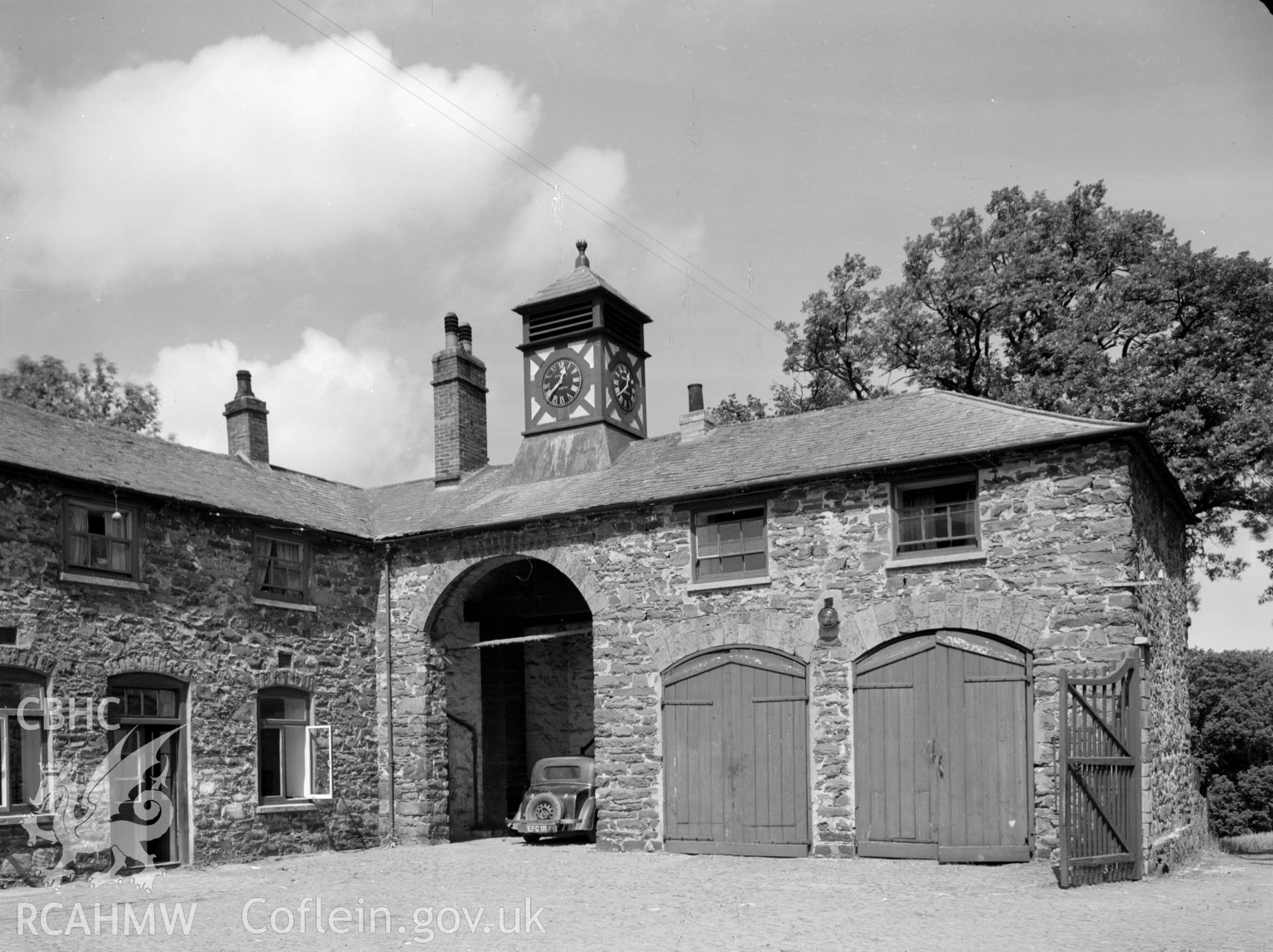 Stone built, two storey stable and coach house. Slate hipped roof, with a clock "tower".