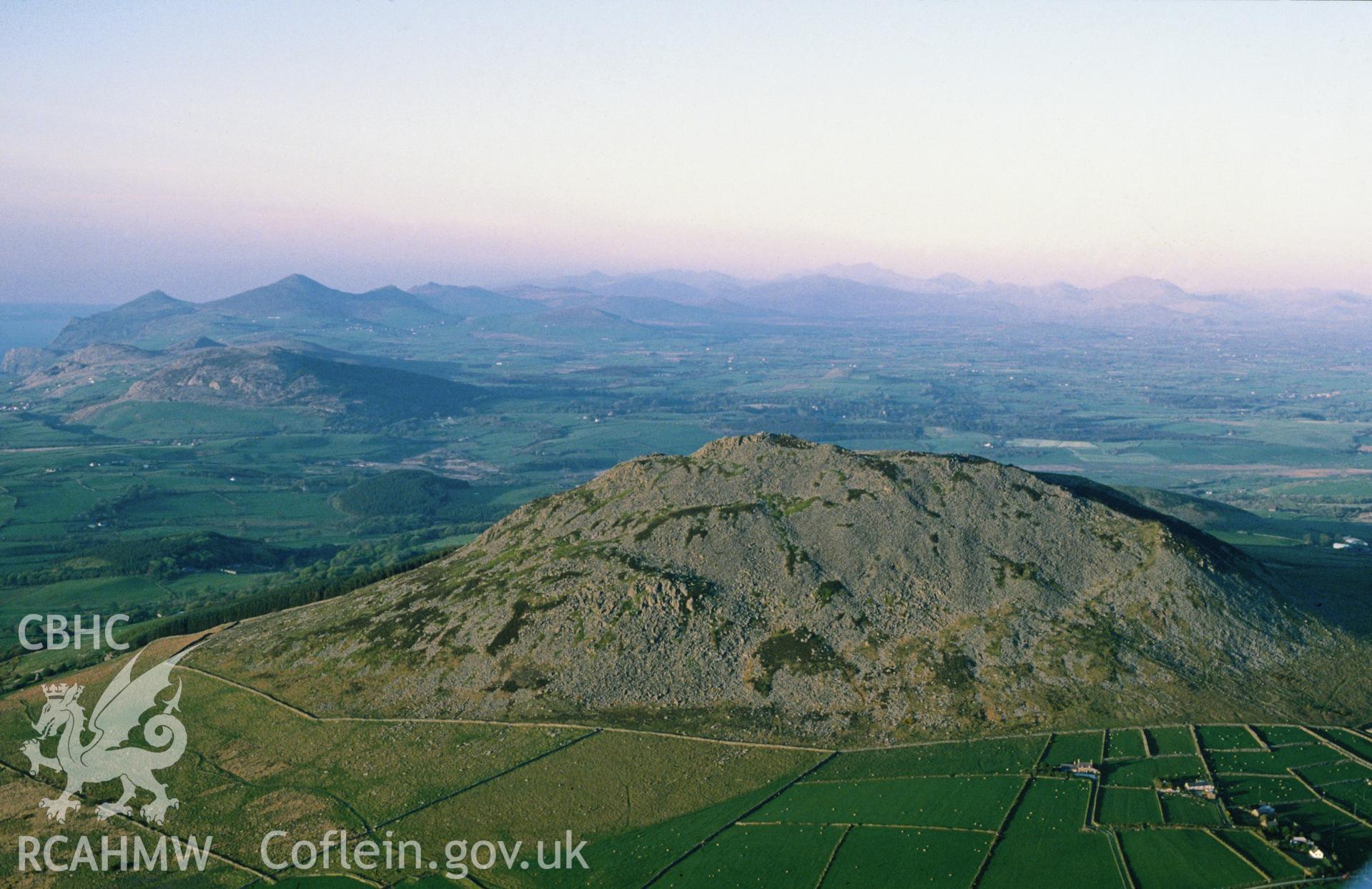 Slide of RCAHMW colour oblique aerial photograph of Hillfort; Carn Fadrun, taken by C.R. Musson, 9/5/1989.