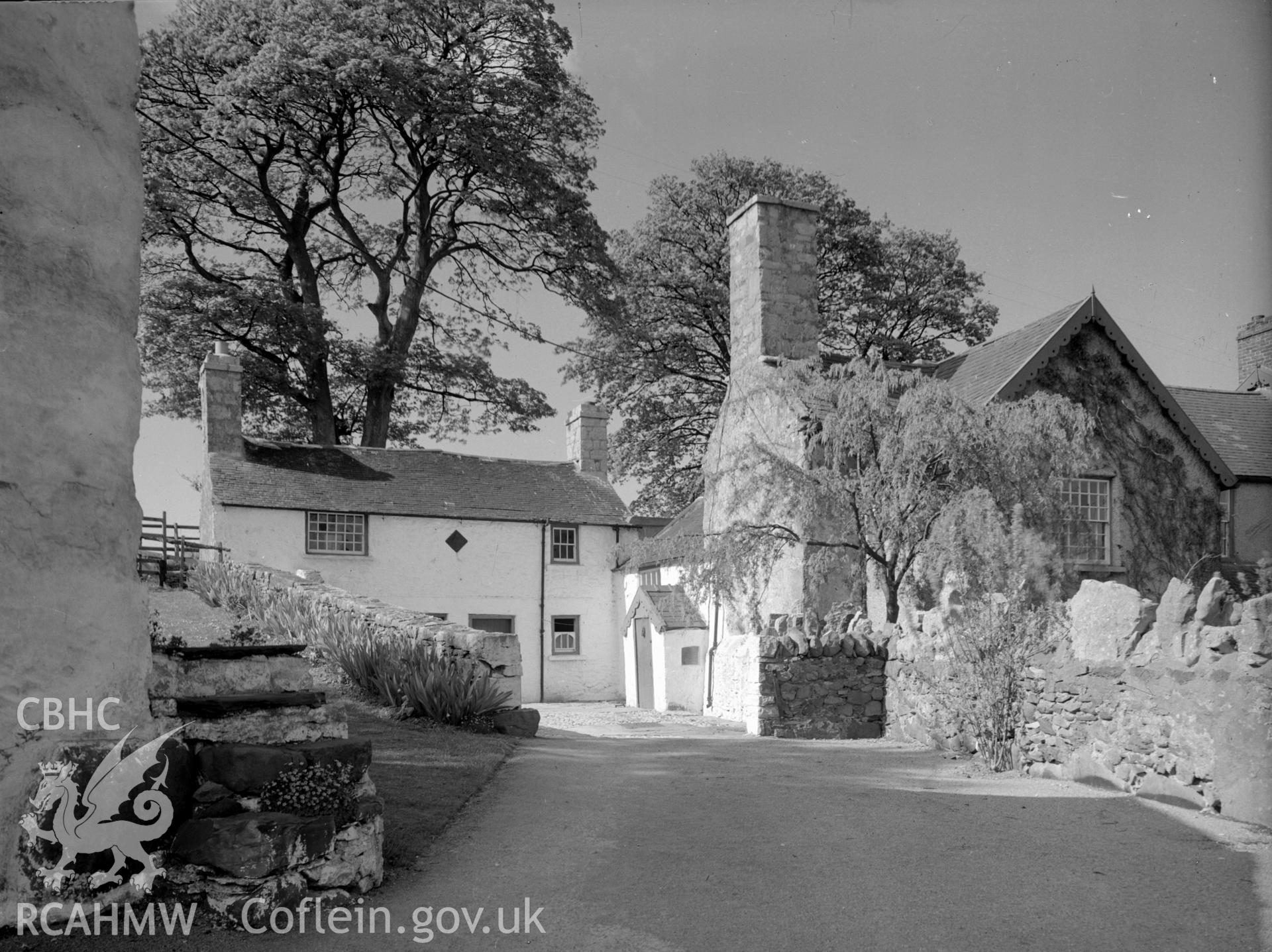 A view of house with pitched slate roofing and two chimneys, situated at either end of the roof.