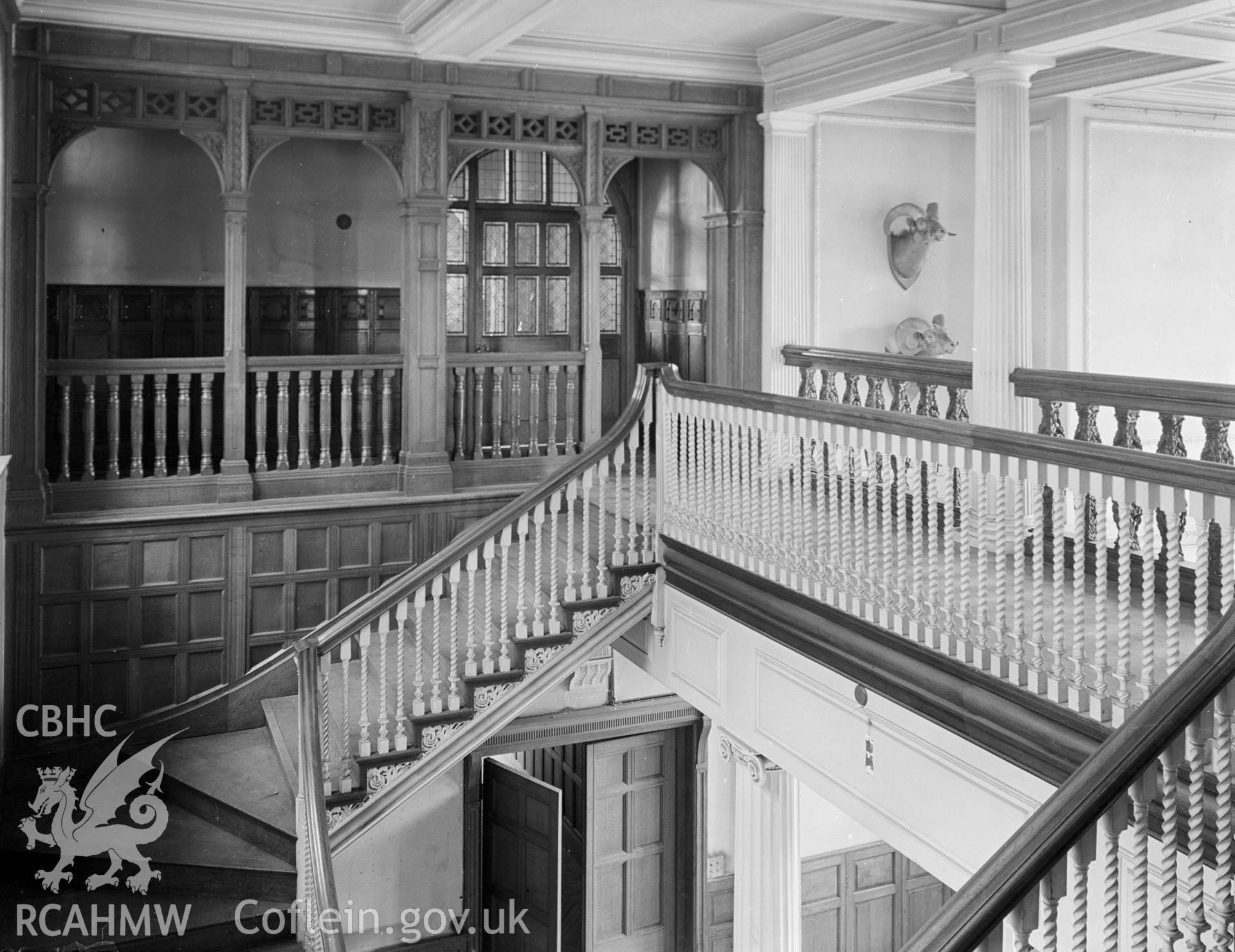 A photo of the main staircase and wooden banister leading to the second floor walkway.