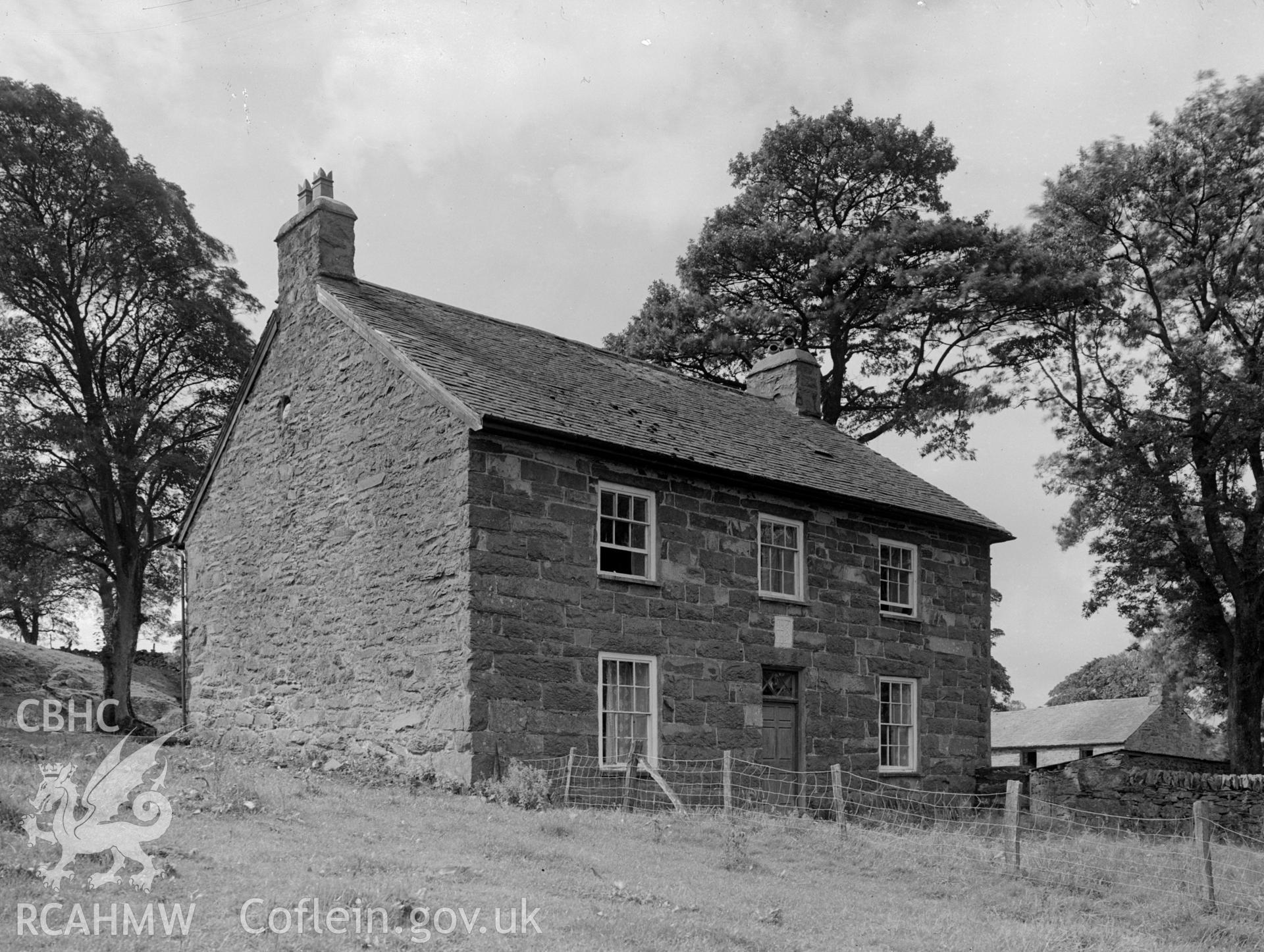 Rectangular 17th century stone, two storey, house with a pitched slate roof and two gable chimneys.