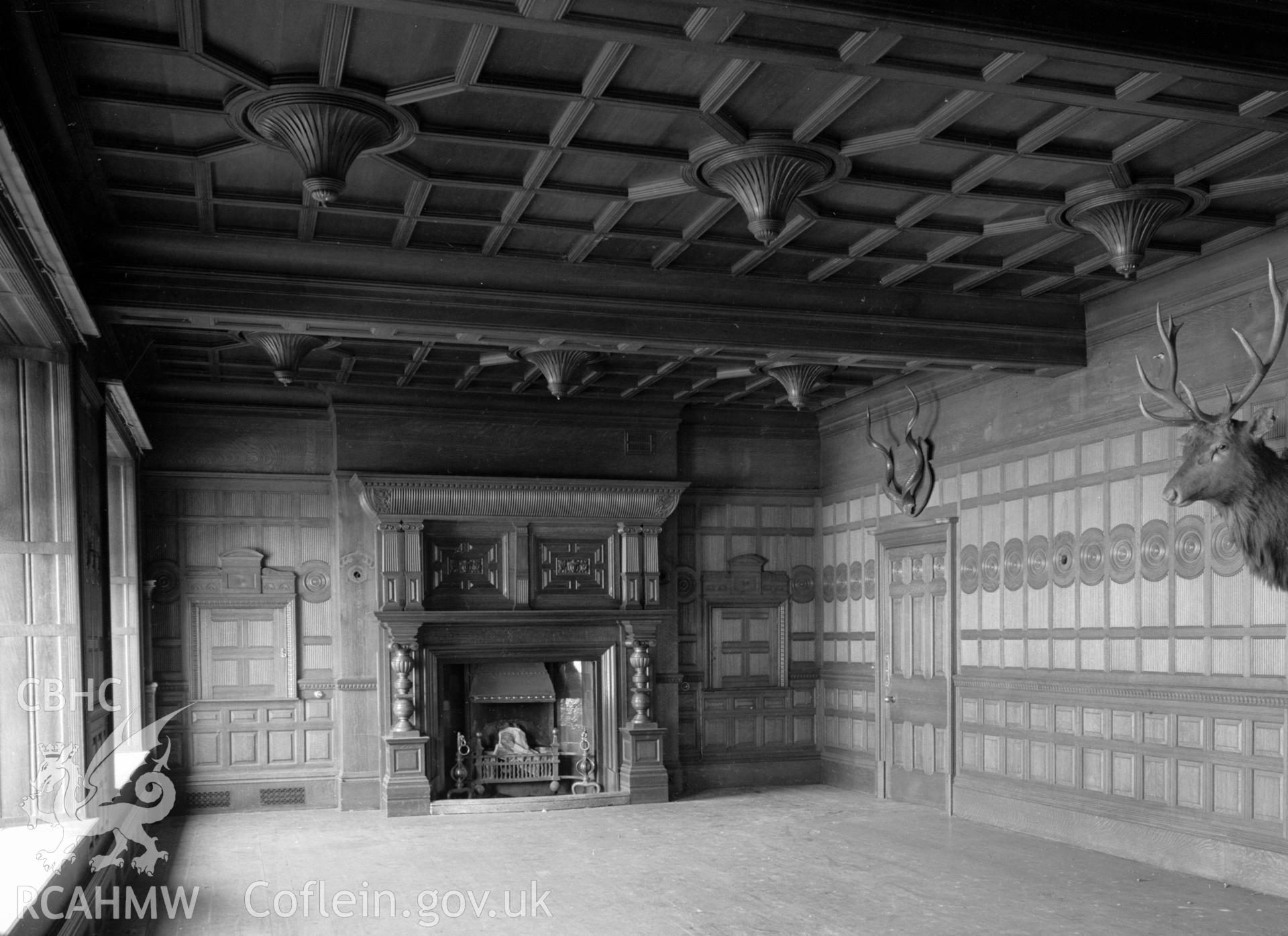 Oak panelled dining room walls and ceiling, and a large fireplace with carved surround.
