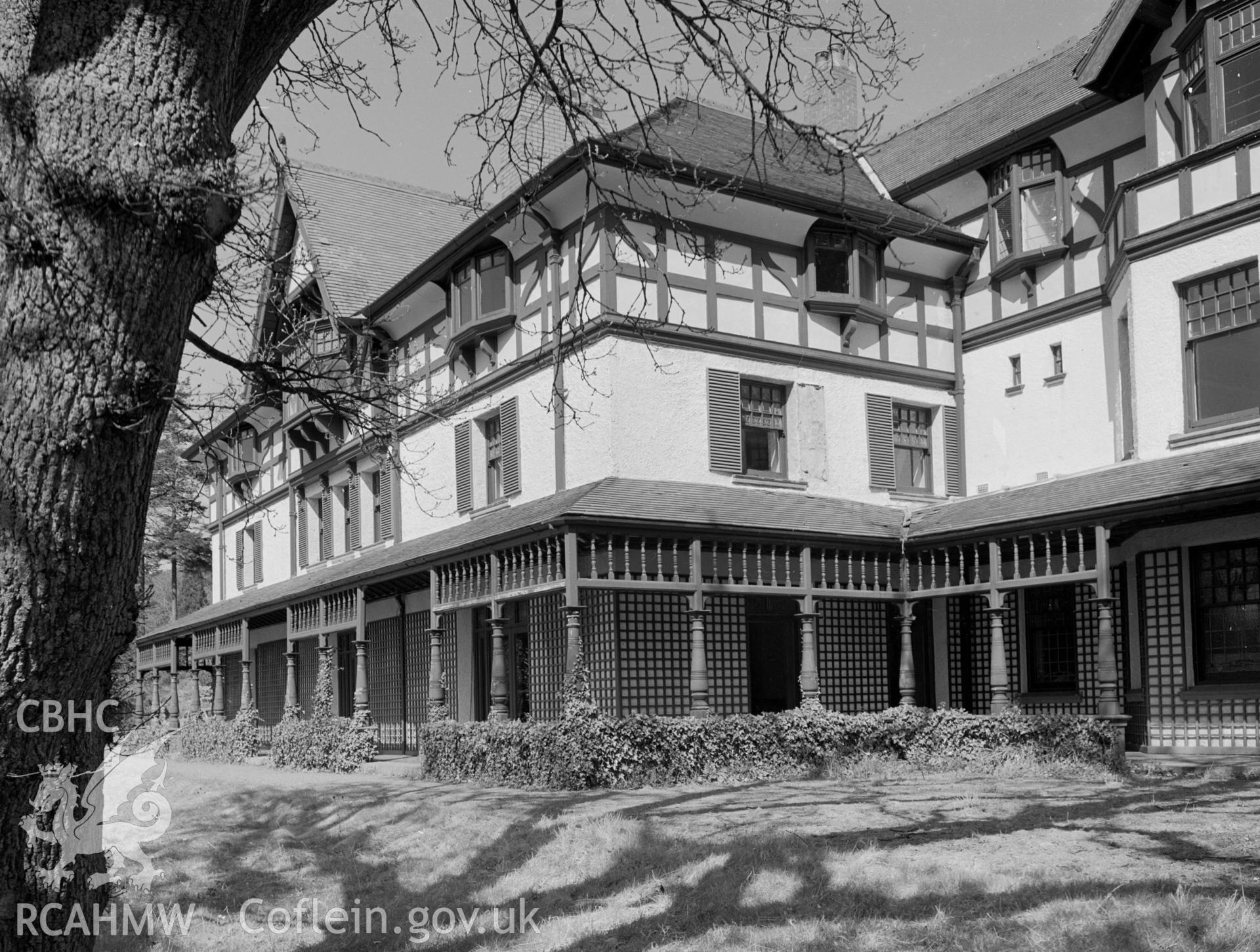 A view of a large country mansion with a veranda that encompasses the house.