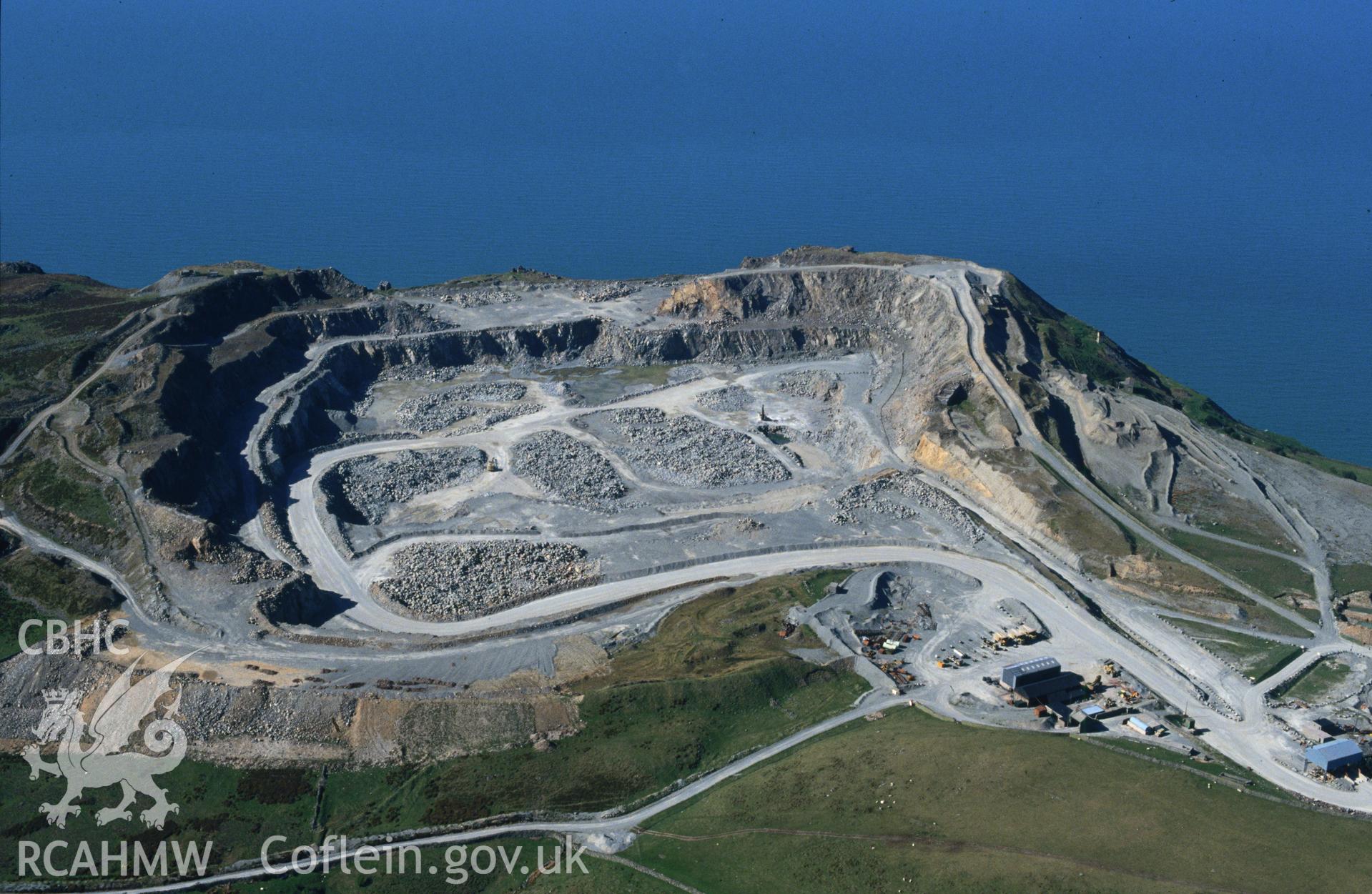 RCAHMW colour slide oblique aerial photograph of Penmaenmawr Stone Quarry, Penmaenmawr, taken by C.R. Musson, 30/04/94